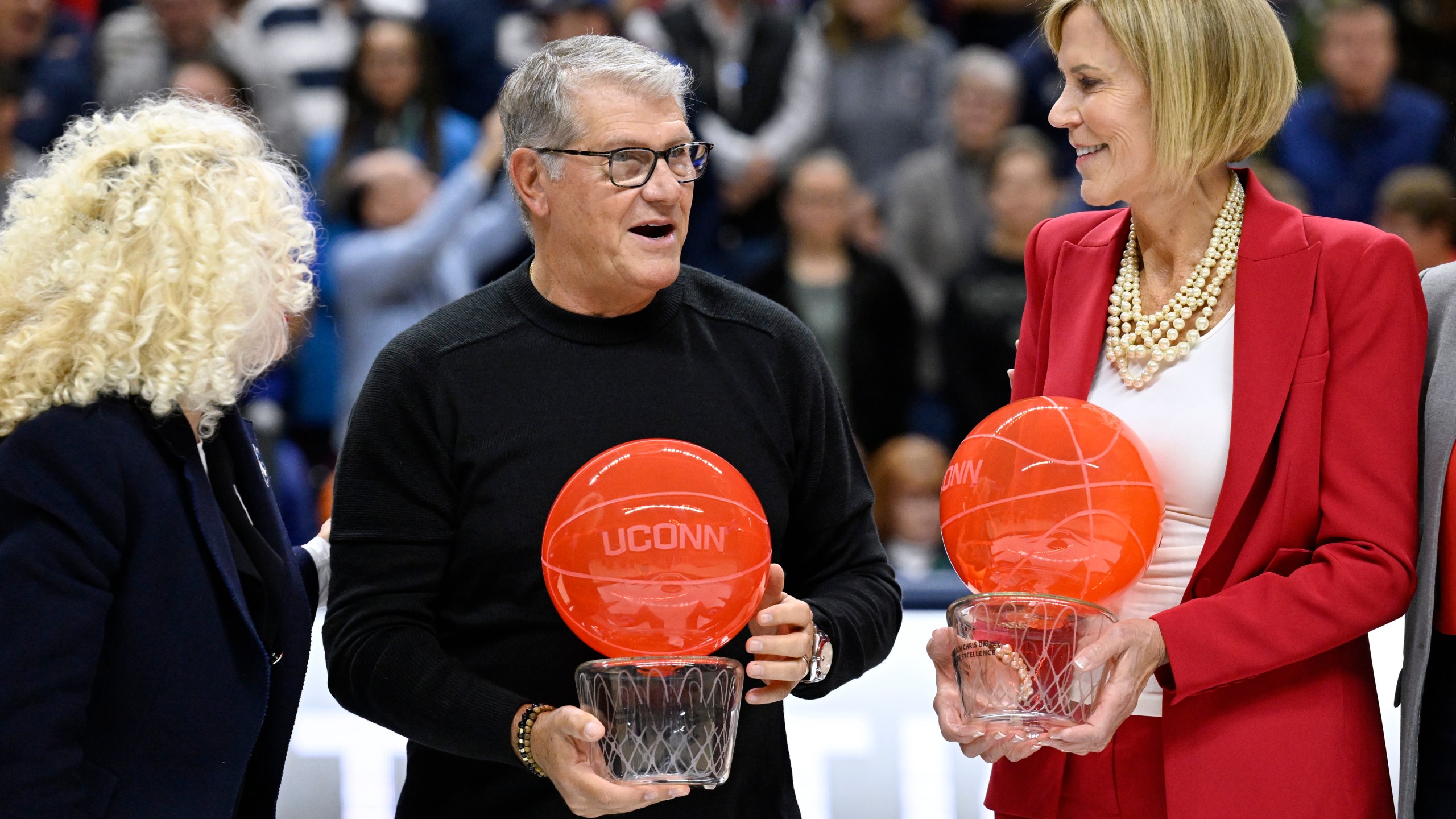 UConn head coach Geno Auriemma and associate head coach Chris Dailey receive recognition from UConn president Radenka Maric, left, during a pregame ceremony honoring Auriemma and longtime assistant Chris Dailey, Wednesday, Nov. 20, 2024, in Storrs, Conn. (AP Photo/Jessica Hill)