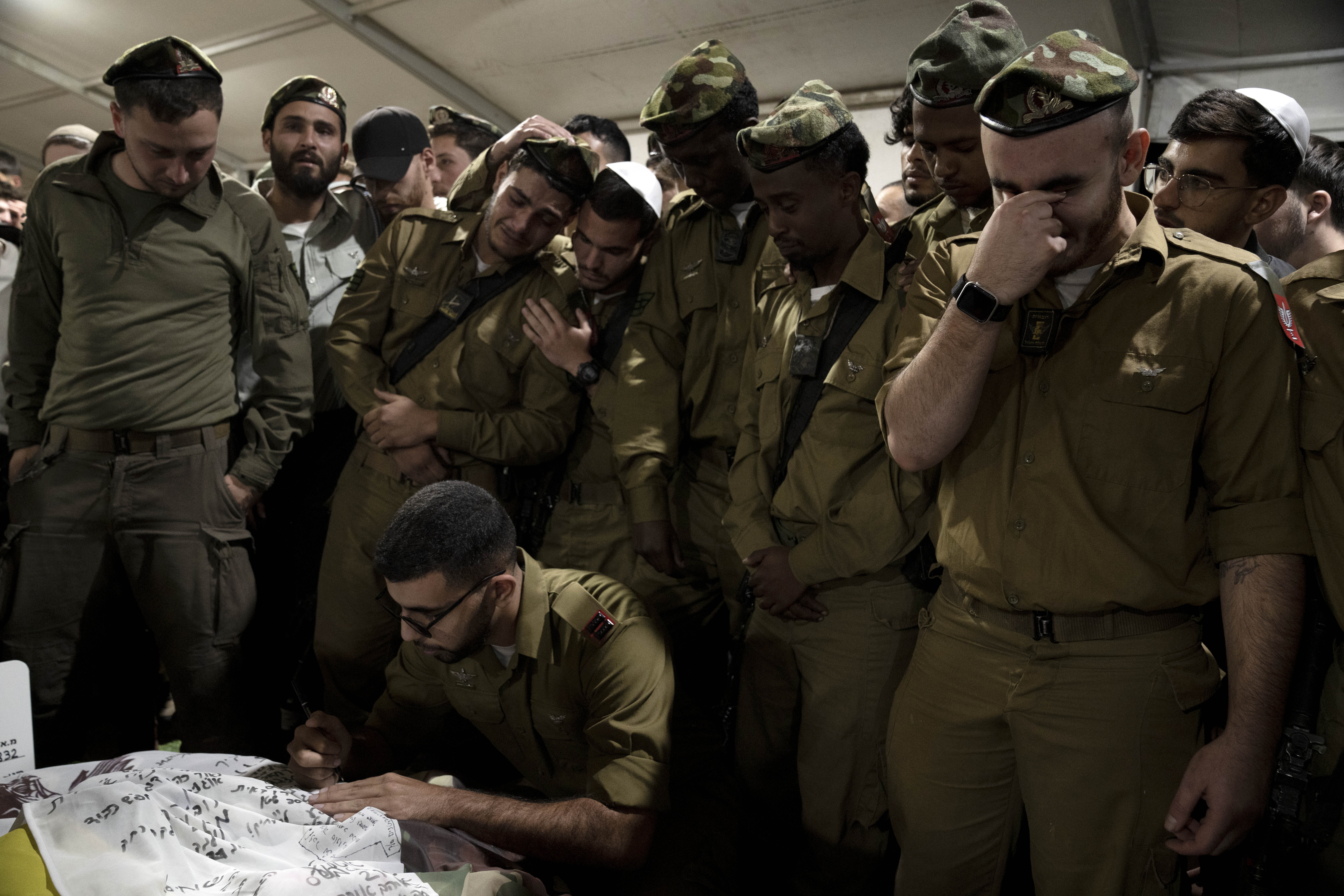 Israeli Defense Forces soldiers mourn at the grave of Sgt. First Class (res.) Roi Sasson, who was killed in action in the Gaza Strip, during his funeral at Mt. Herzl military cemetery in Jerusalem, Wednesday, Nov. 20, 2024. (AP Photo/Maya Alleruzzo)