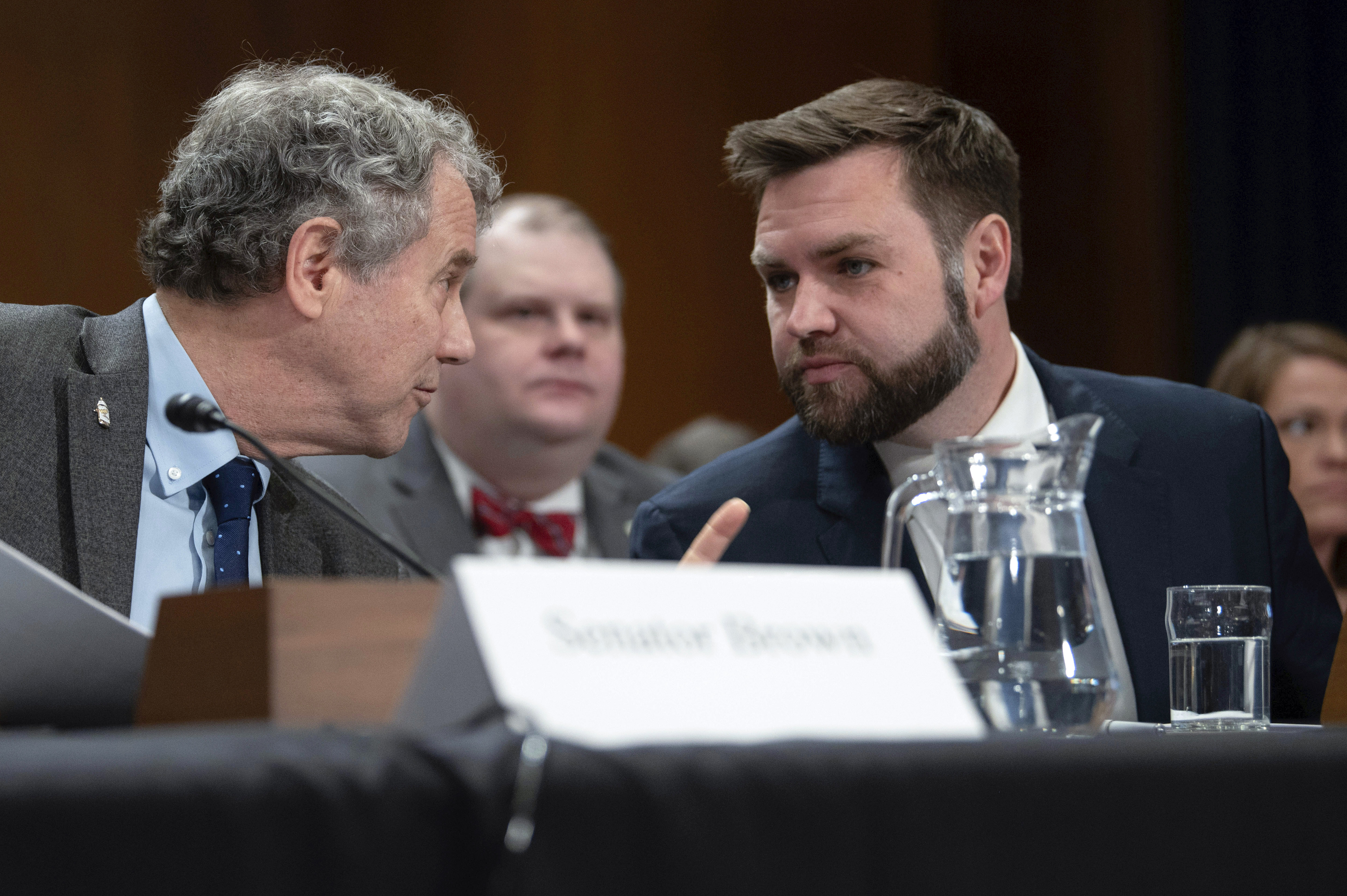 FILE - Sen. JD Vance, R-Ohio, right, speaks with Sen. Sherrod Brown, D-Ohio, before testifying at a hearing, March 9, 2023, in Washington. (AP Photo/Kevin Wolf, File)