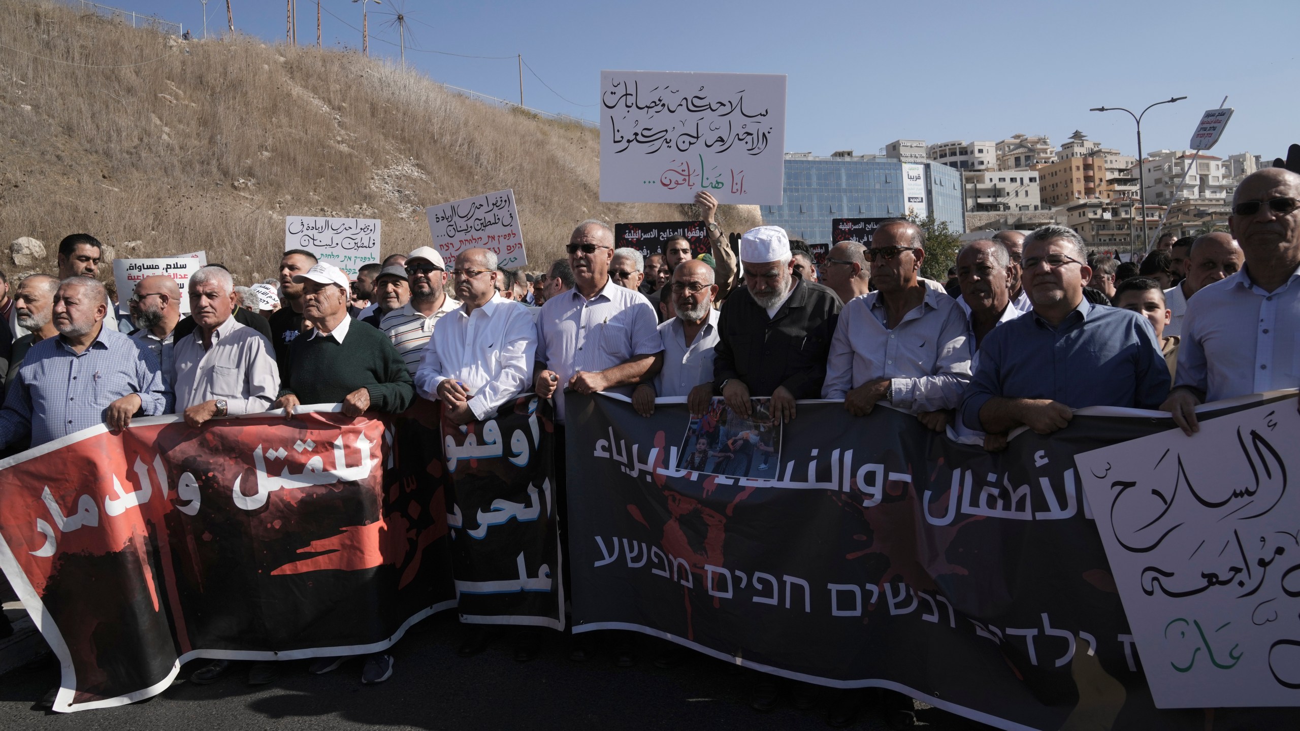 Lawmaker Ahmad Tibi, fifth from left, joins Palestinian citizens of Israel in a march against Israel's military operations in the Gaza Strip, in Umm al-Fahm, Israel, Friday, Nov. 15, 2024. (AP Photo/Mahmoud Illean)