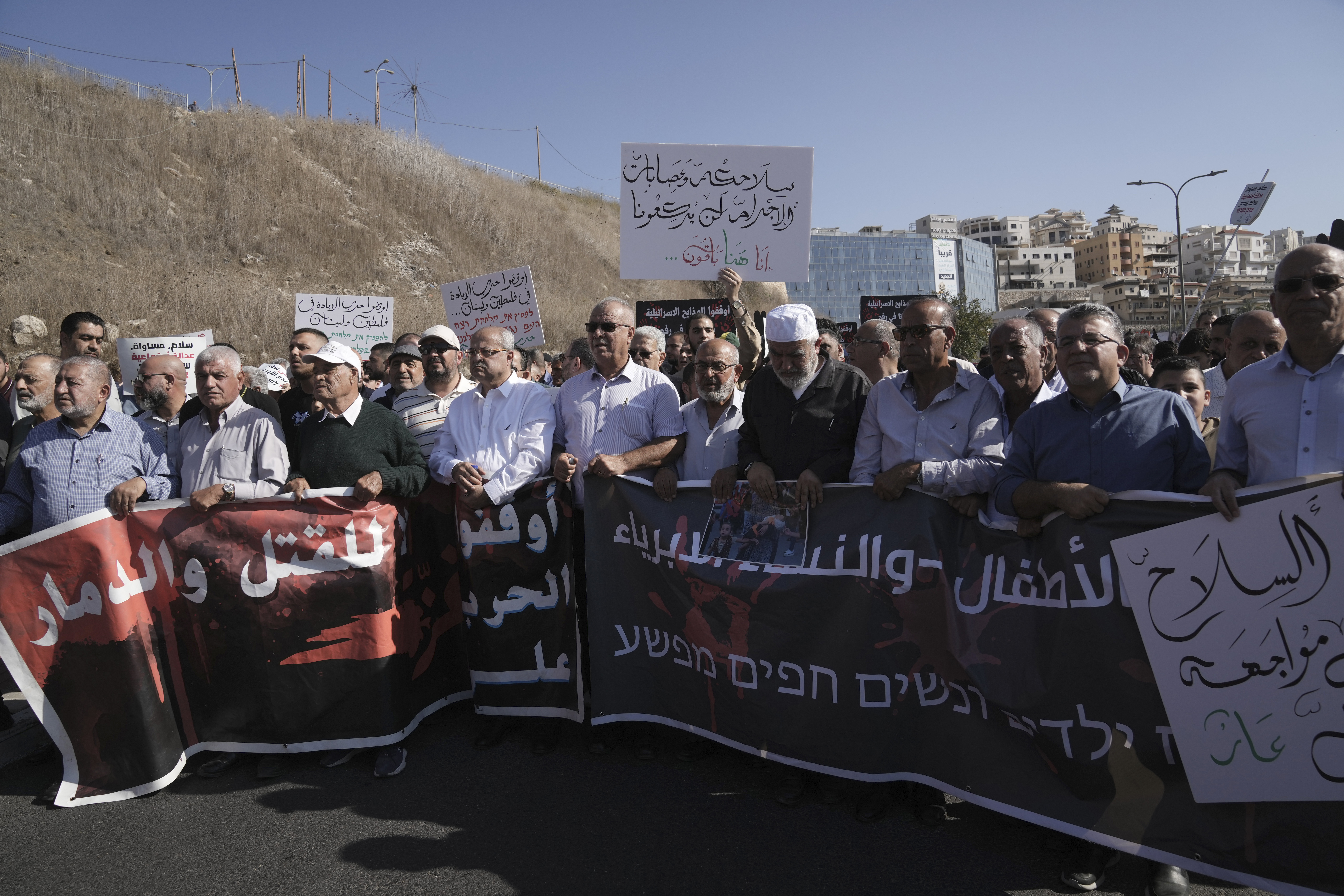 Lawmaker Ahmad Tibi, fifth from left, joins Palestinian citizens of Israel in a march against Israel's military operations in the Gaza Strip, in Umm al-Fahm, Israel, Friday, Nov. 15, 2024. (AP Photo/Mahmoud Illean)