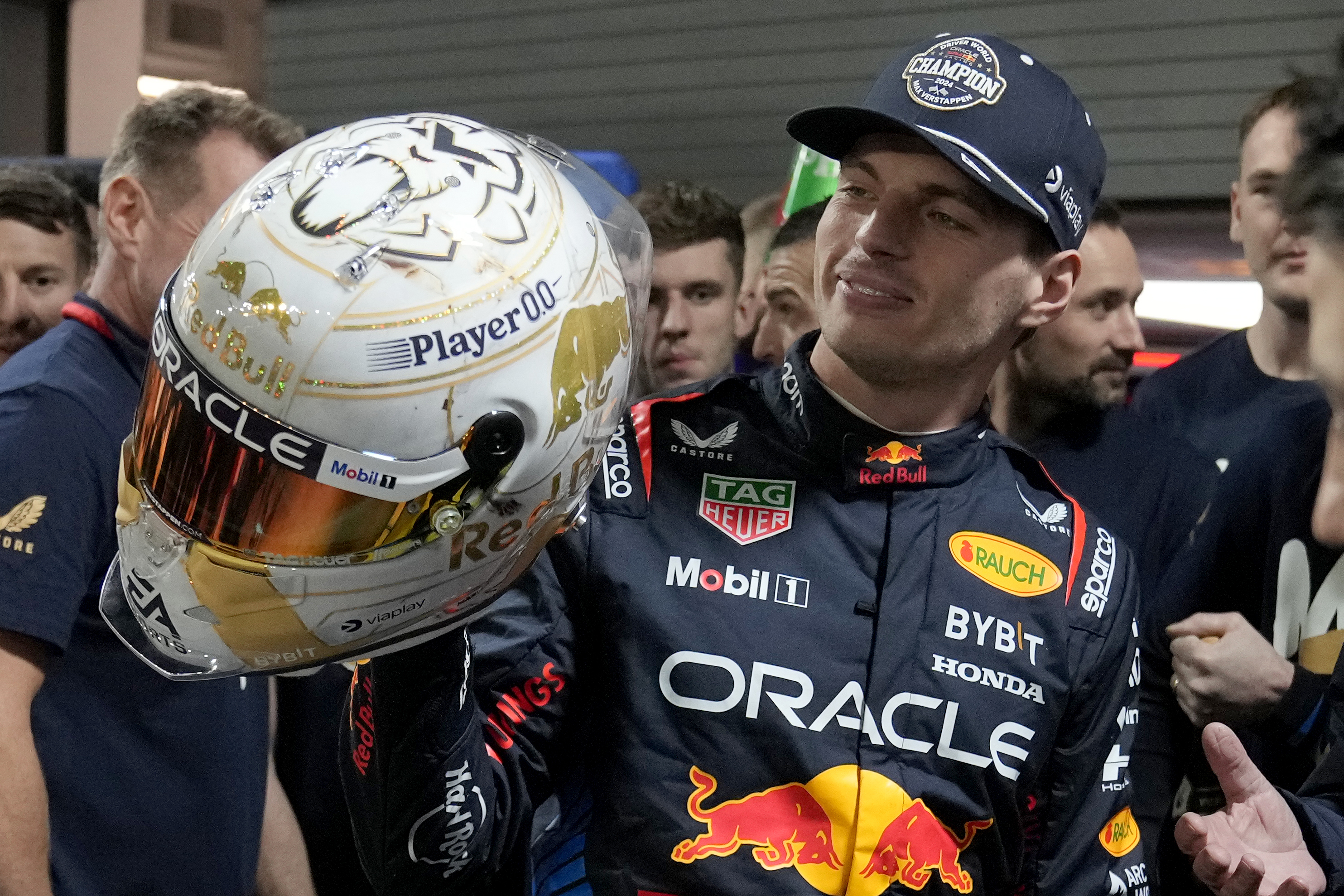 Red Bull driver Max Verstappen, of the Netherlands, looks at a helmet given to him by his team after winning the Formula 1 championship with his team after the F1 Las Vegas Grand Prix auto race, Sunday, Nov. 24, 2024, in Las Vegas. (AP Photo/Matt York)