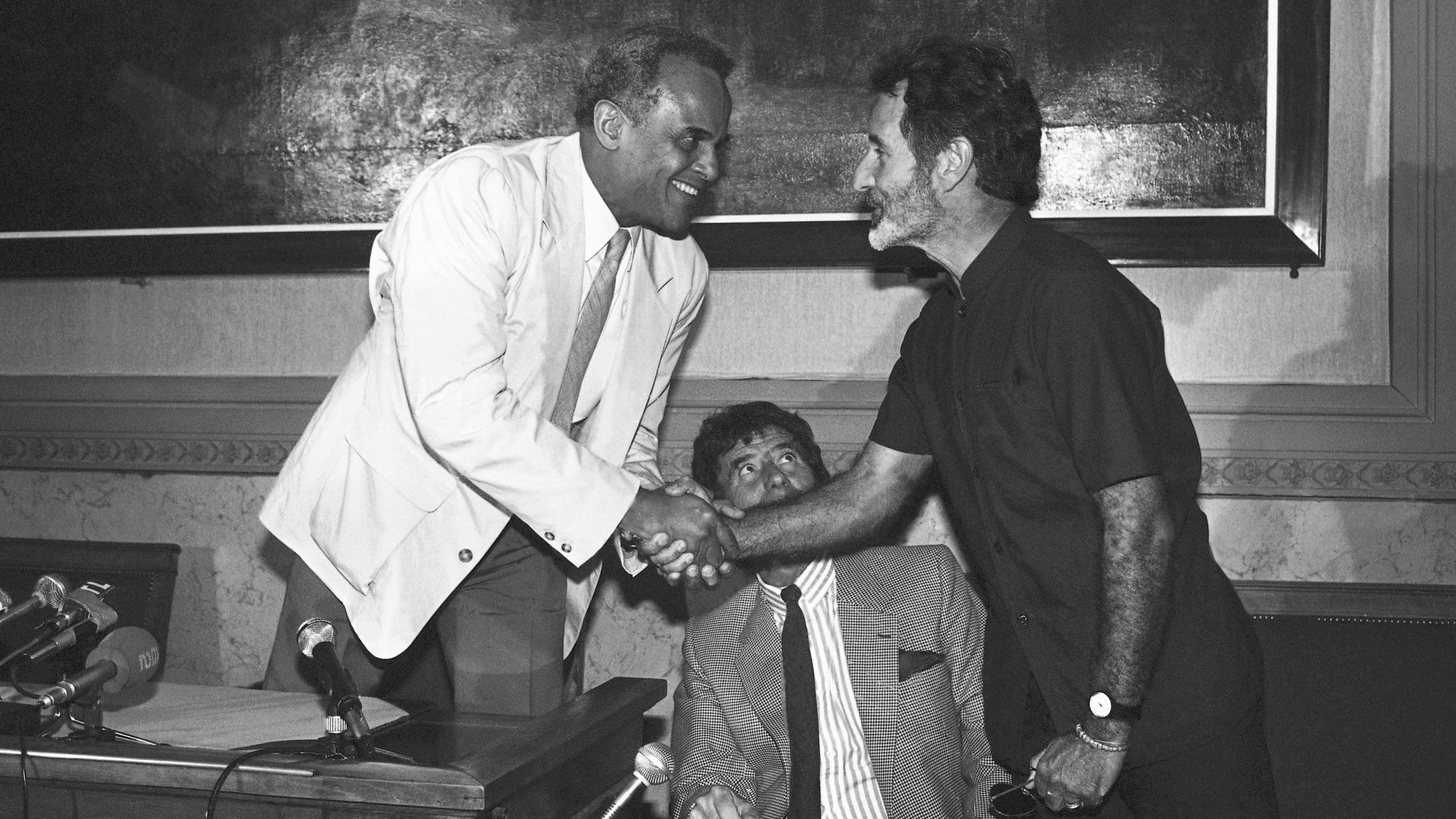 FILE - South African writer Breyten Breytenbach, right, and American actor and singer Harry Belafonte shake hands during a press conference in Paris, on June 18, 1986. (AP Photo, File)