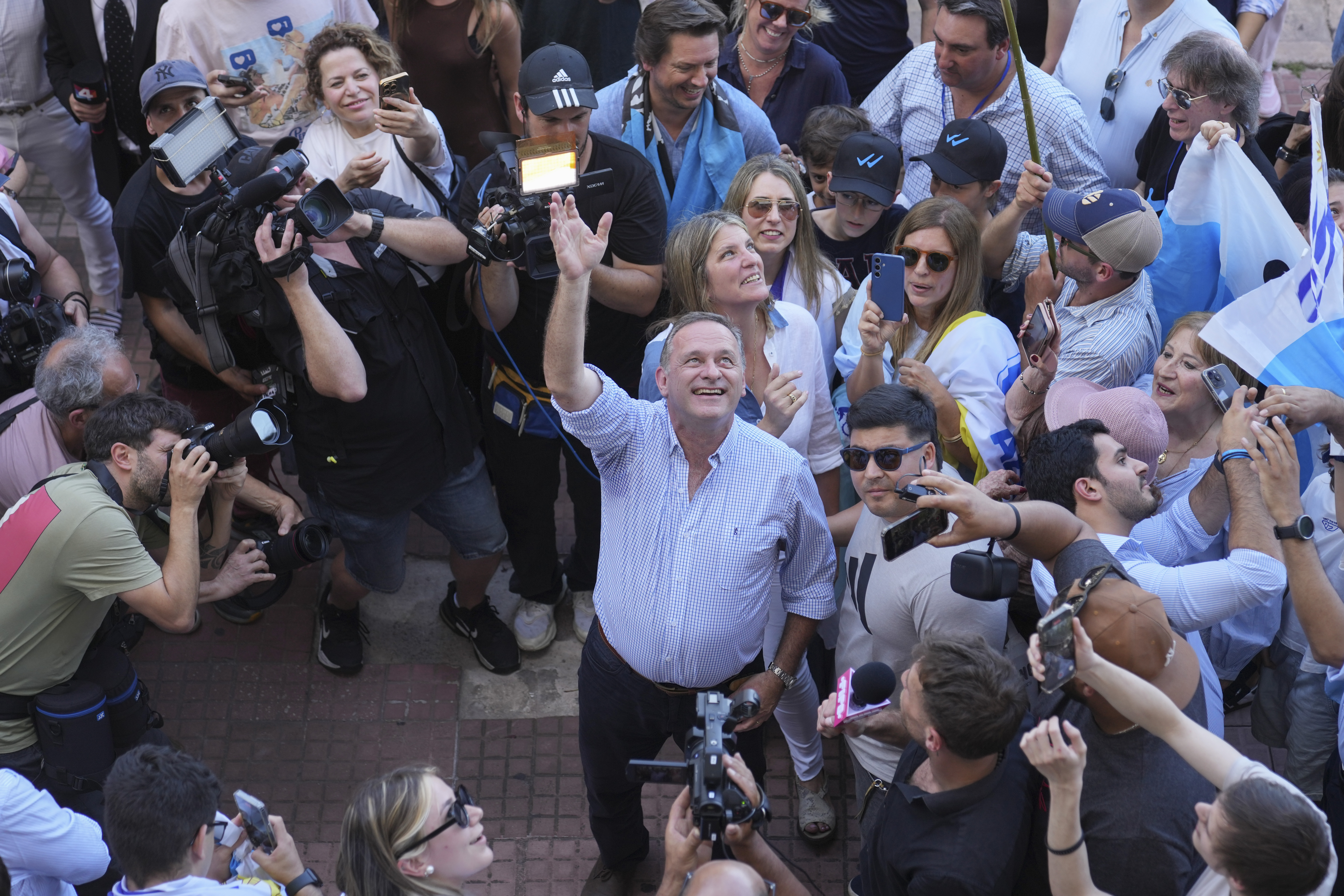 Alvaro Delgado, candidate for the ruling National Party, waves after voting in the presidential run-off election in Montevideo, Uruguay, Sunday, Nov. 24, 2024. (AP Photo/Natacha Pisarenko)