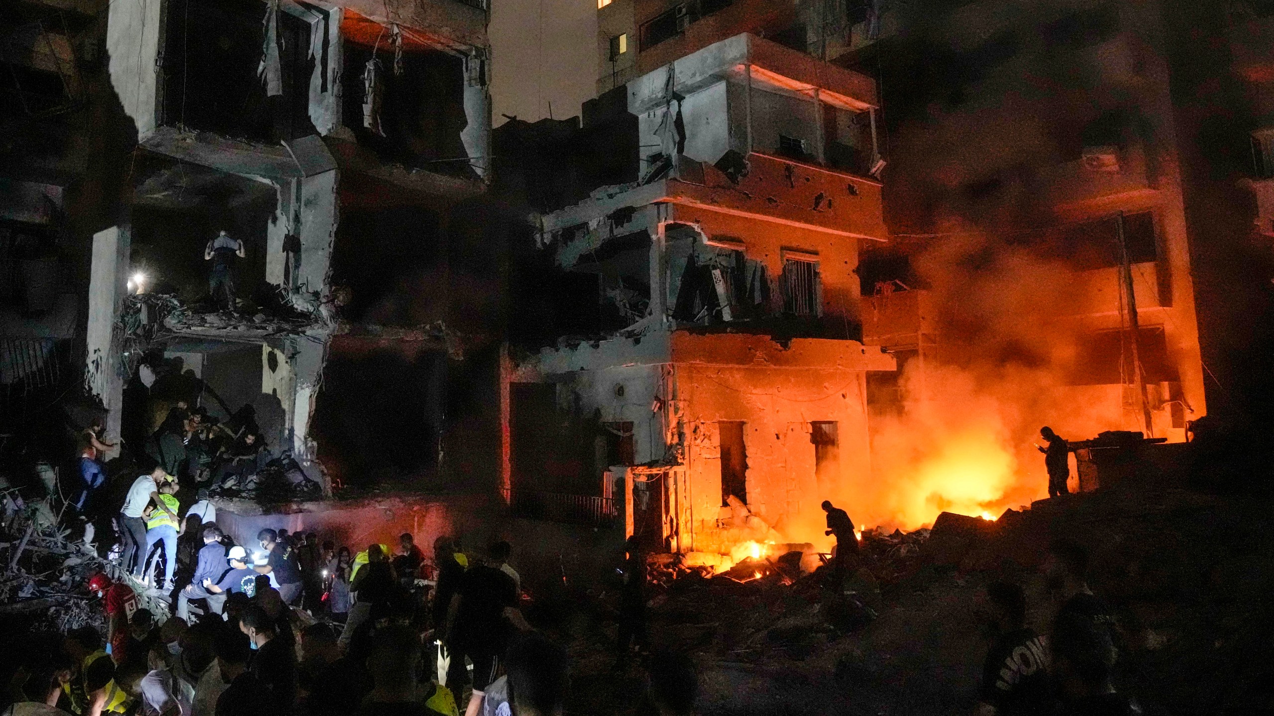 FILE - People gather in front of buildings hit by an Israeli airstrike in central Beirut, Lebanon, on Oct. 10, 2024. (AP Photo/Bilal Hussein, File)