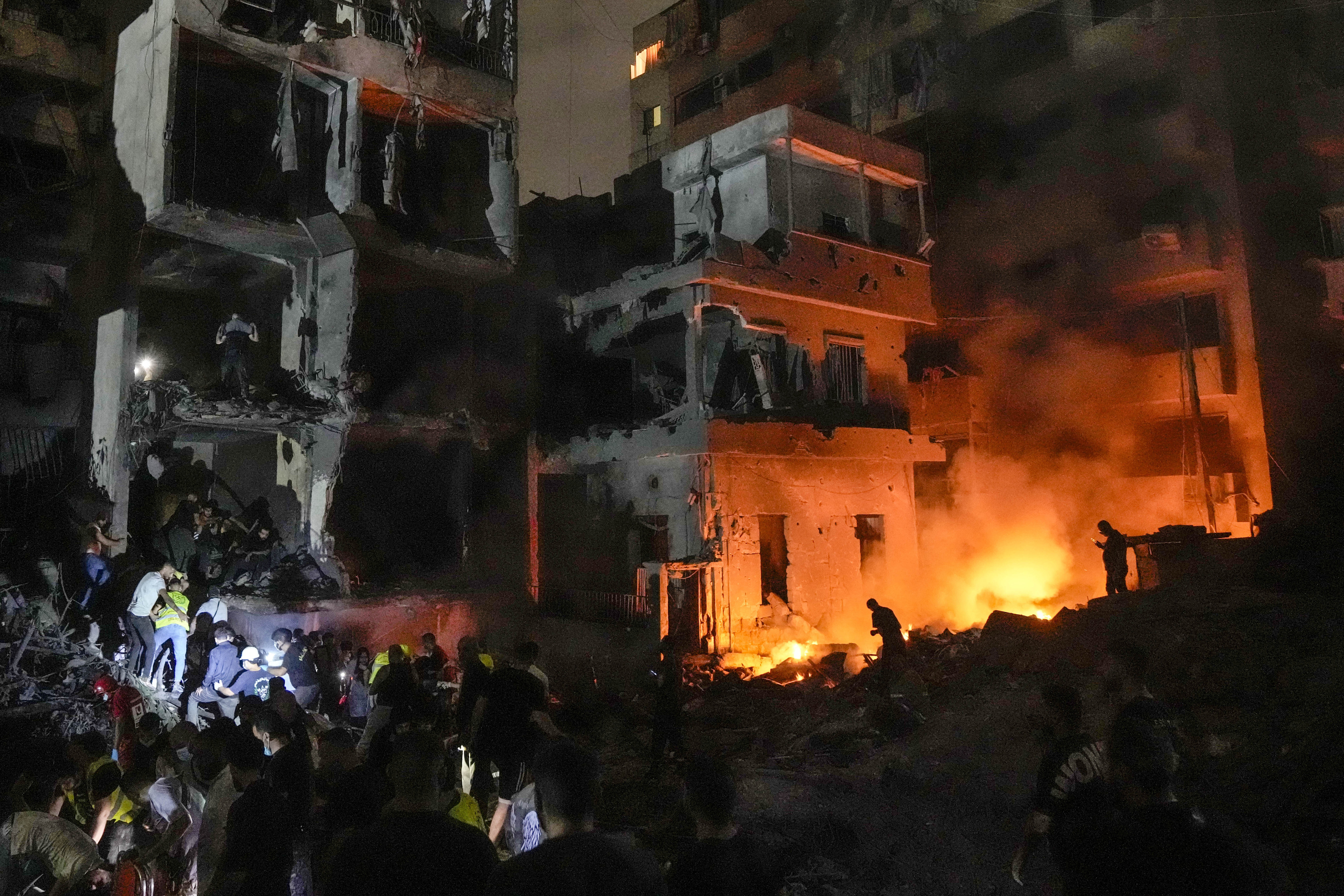 FILE - People gather in front of buildings hit by an Israeli airstrike in central Beirut, Lebanon, on Oct. 10, 2024. (AP Photo/Bilal Hussein, File)