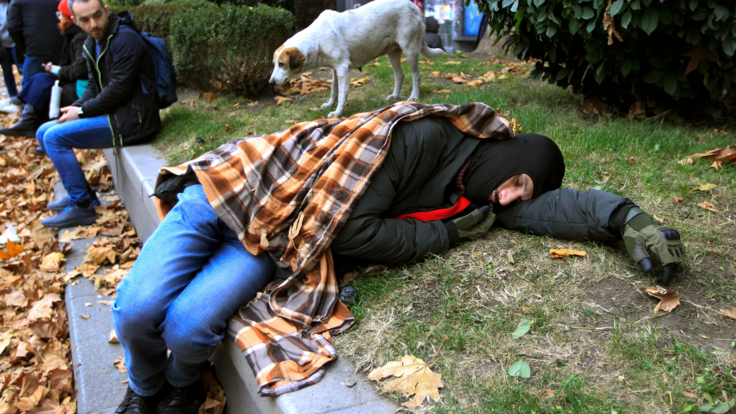 Protesters rest in a street during a rally to demand new parliamentary elections in the country, near the Parliament's building in Tbilisi, Georgia, on Monday, Nov. 25, 2024. (AP Photo/Shakh Aivazov)