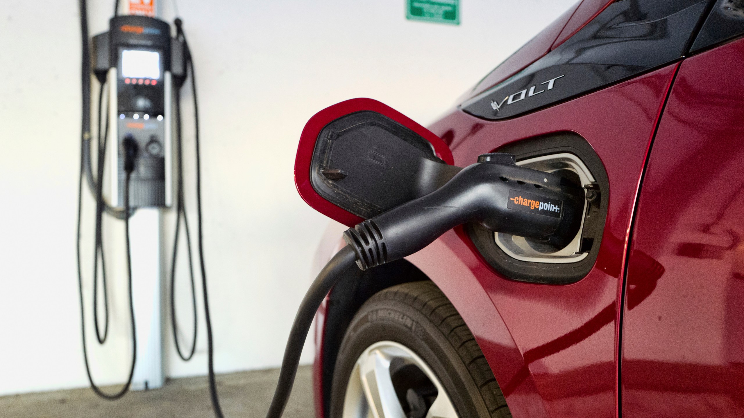 FILE - An electric vehicle is charged at a parking garage in Los Angeles, Oct. 17, 2018. (AP Photo/Richard Vogel, File)