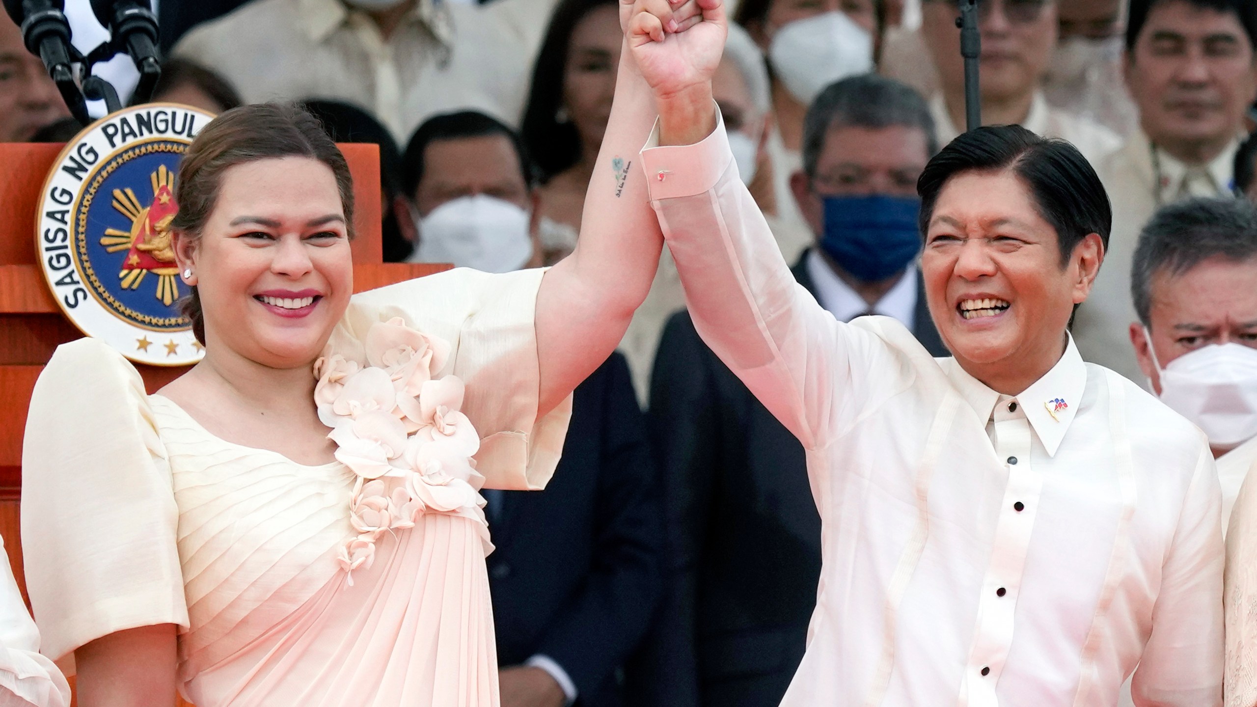 FILE - Philippine President Ferdinand Marcos Jr., center right, and Vice President Sara Duterte, daughter of former Philippine President Rodrigo Duterte, raise hands during the inauguration ceremony at National Museum on Thursday, June 30, 2022 in Manila, Philippines. (AP Photo/Aaron Favila, File)