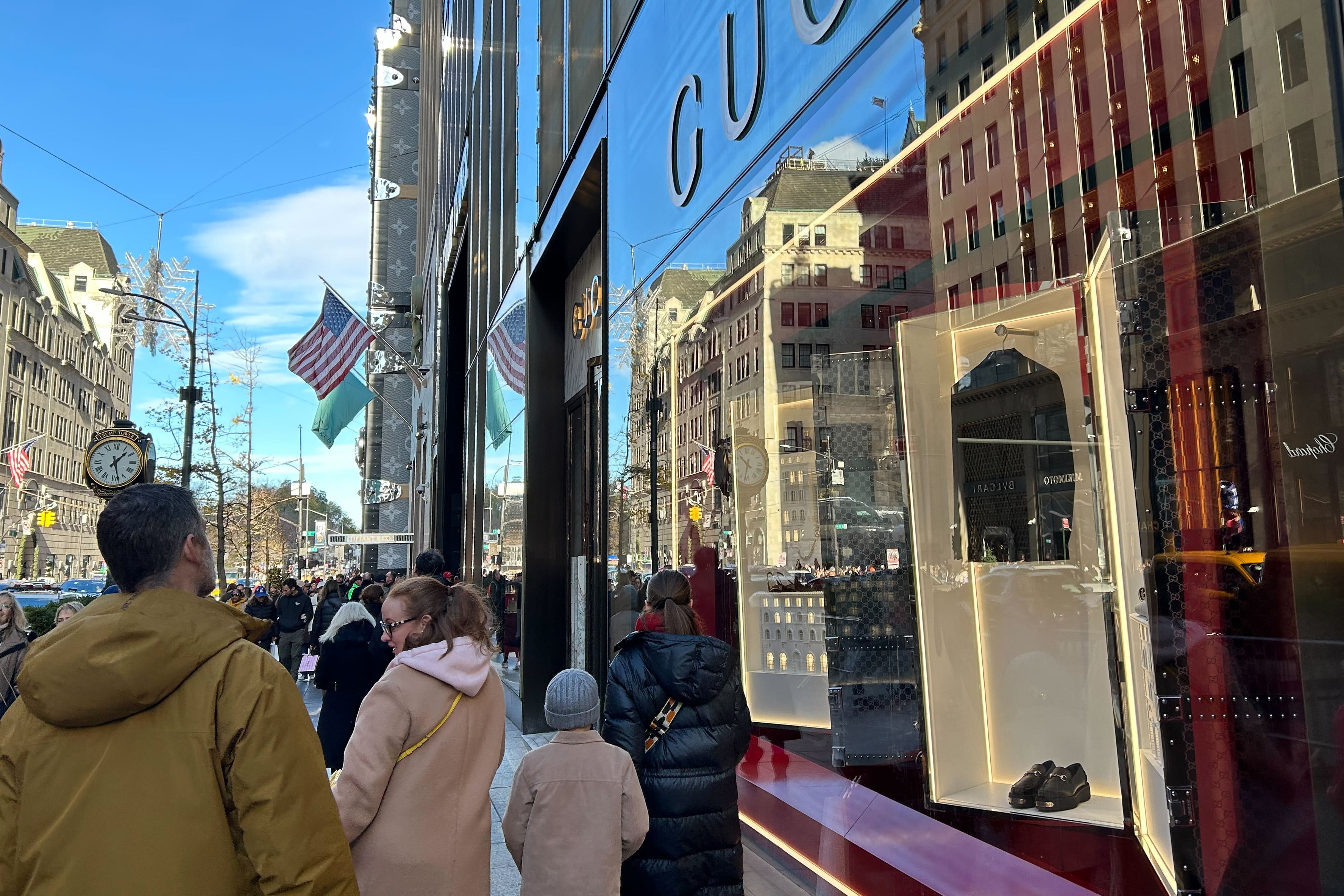 People walk past stores on Fifth Ave. on Sunday, Nov. 24, 2024, in New York. (AP Photo/Anne D'Innocenzio)