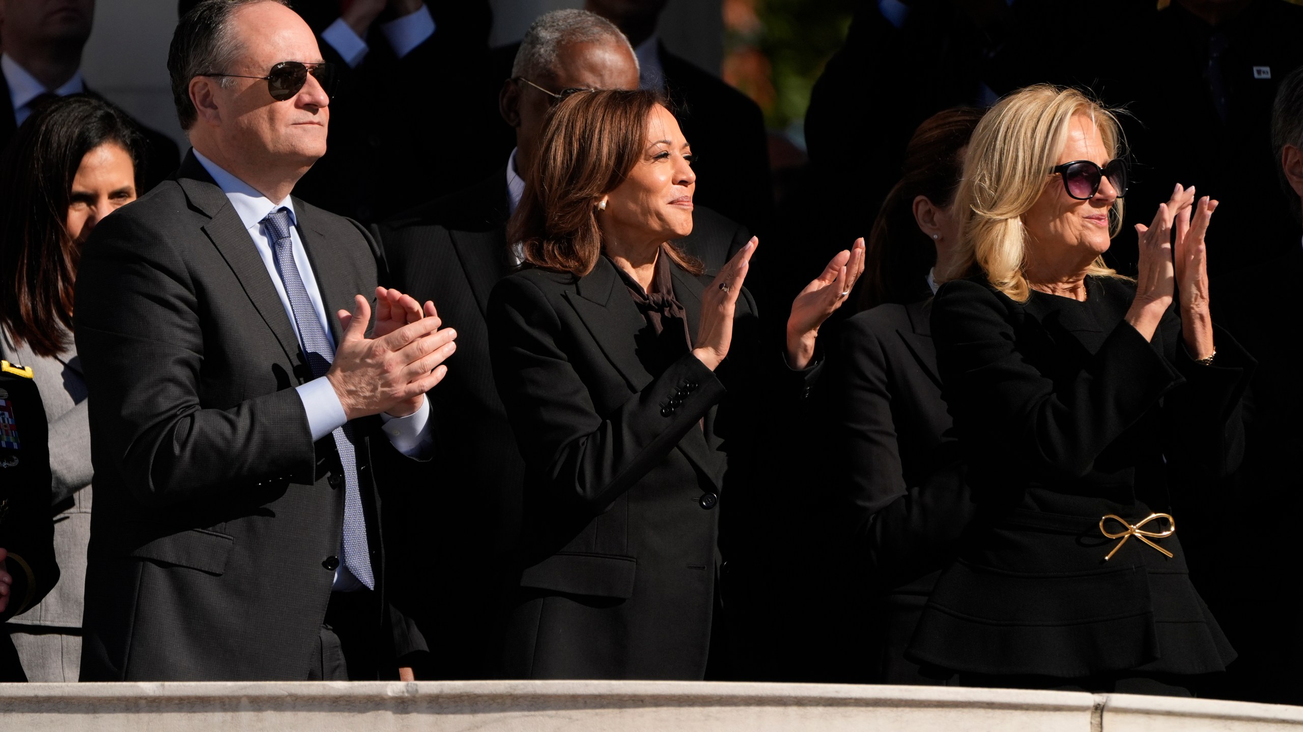 Second gentleman Doug Emhoff, from left, Vice President Kamala Harris and first lady Jill Biden attend the National Veterans Day Observance at the Memorial Amphitheater at Arlington National Cemetery in Arlington, Va., Monday, Nov. 11, 2024. (AP Photo/Mark Schiefelbein)