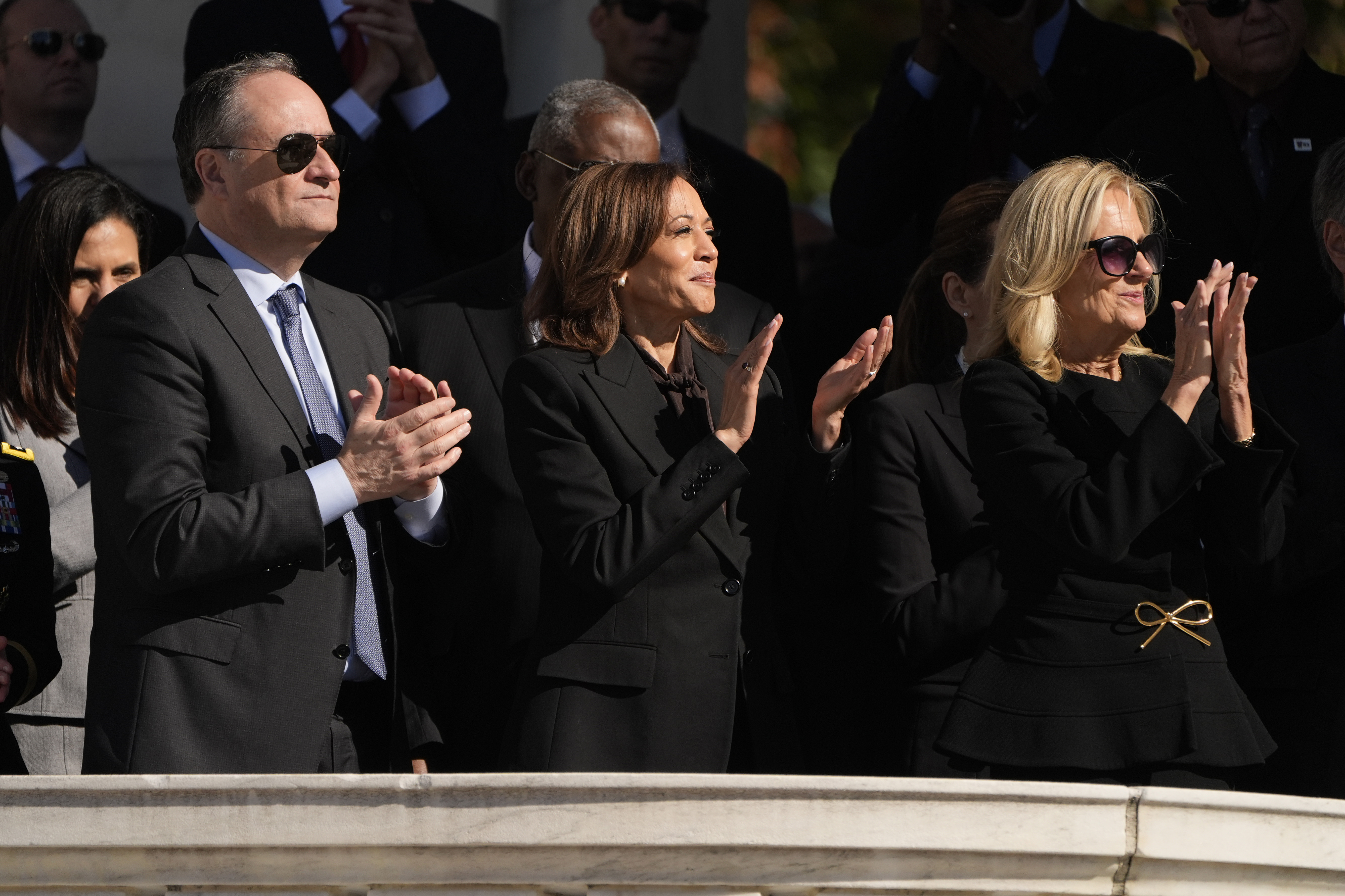 Second gentleman Doug Emhoff, from left, Vice President Kamala Harris and first lady Jill Biden attend the National Veterans Day Observance at the Memorial Amphitheater at Arlington National Cemetery in Arlington, Va., Monday, Nov. 11, 2024. (AP Photo/Mark Schiefelbein)