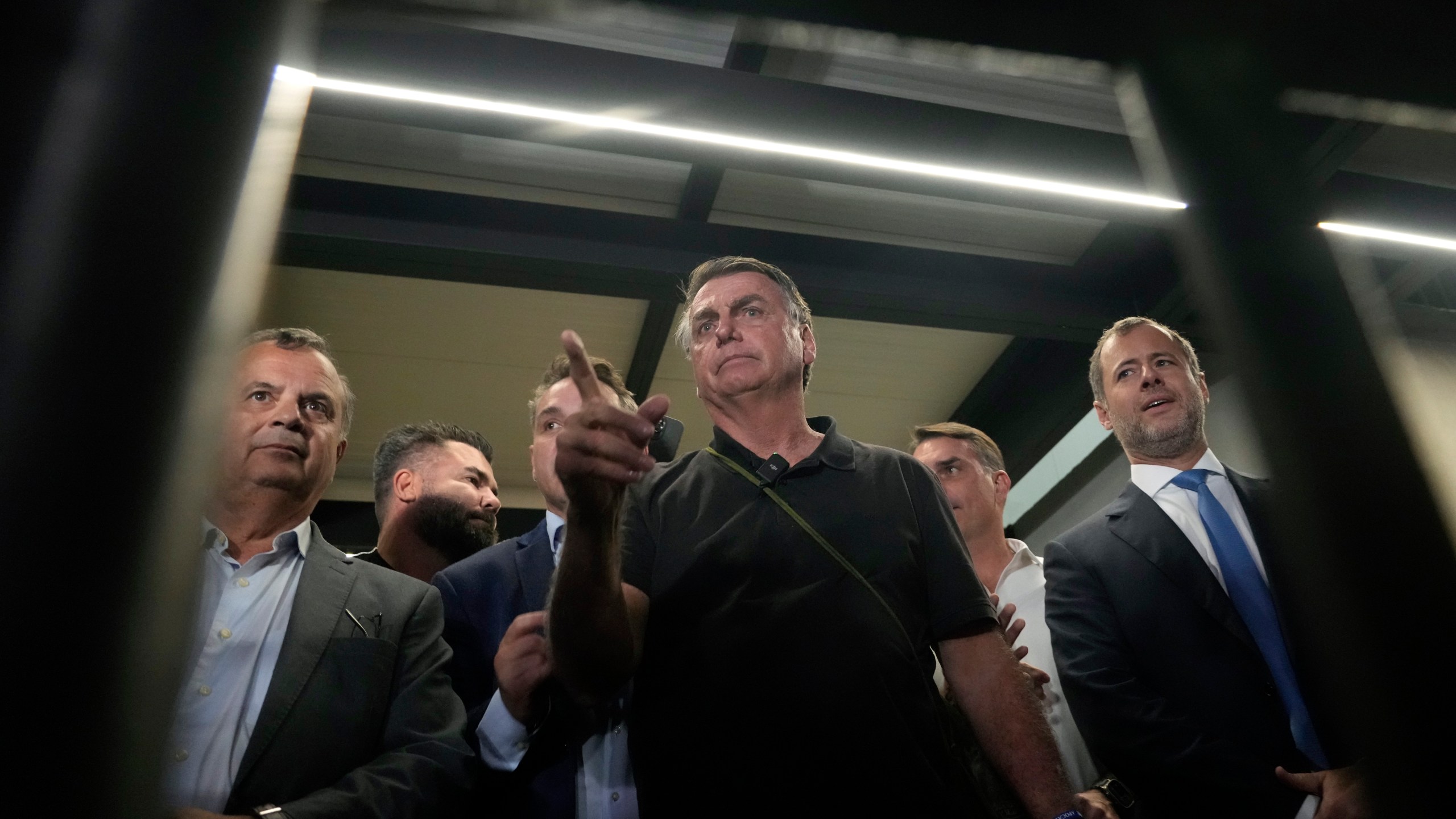 Former President Jair Bolsonaro arrives to speak with the press after being formally charged by the federal police with attempted coup, at the airport in Brasilia, Brazil, Monday, Nov. 25, 2024. (AP Photo/Eraldo Peres)