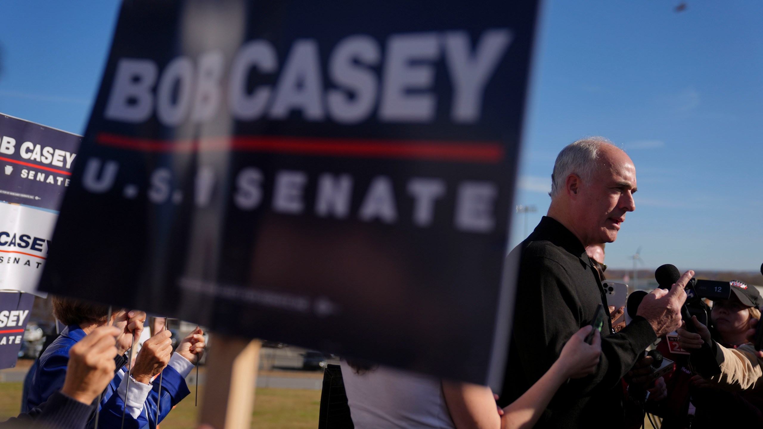 FILE - Sen. Bob Casey, D-Pa., left, stops to speak to members of the media before voting, Tuesday, Nov. 5, 2024, in Scranton, Pa. (AP Photo/Matt Rourke, File)