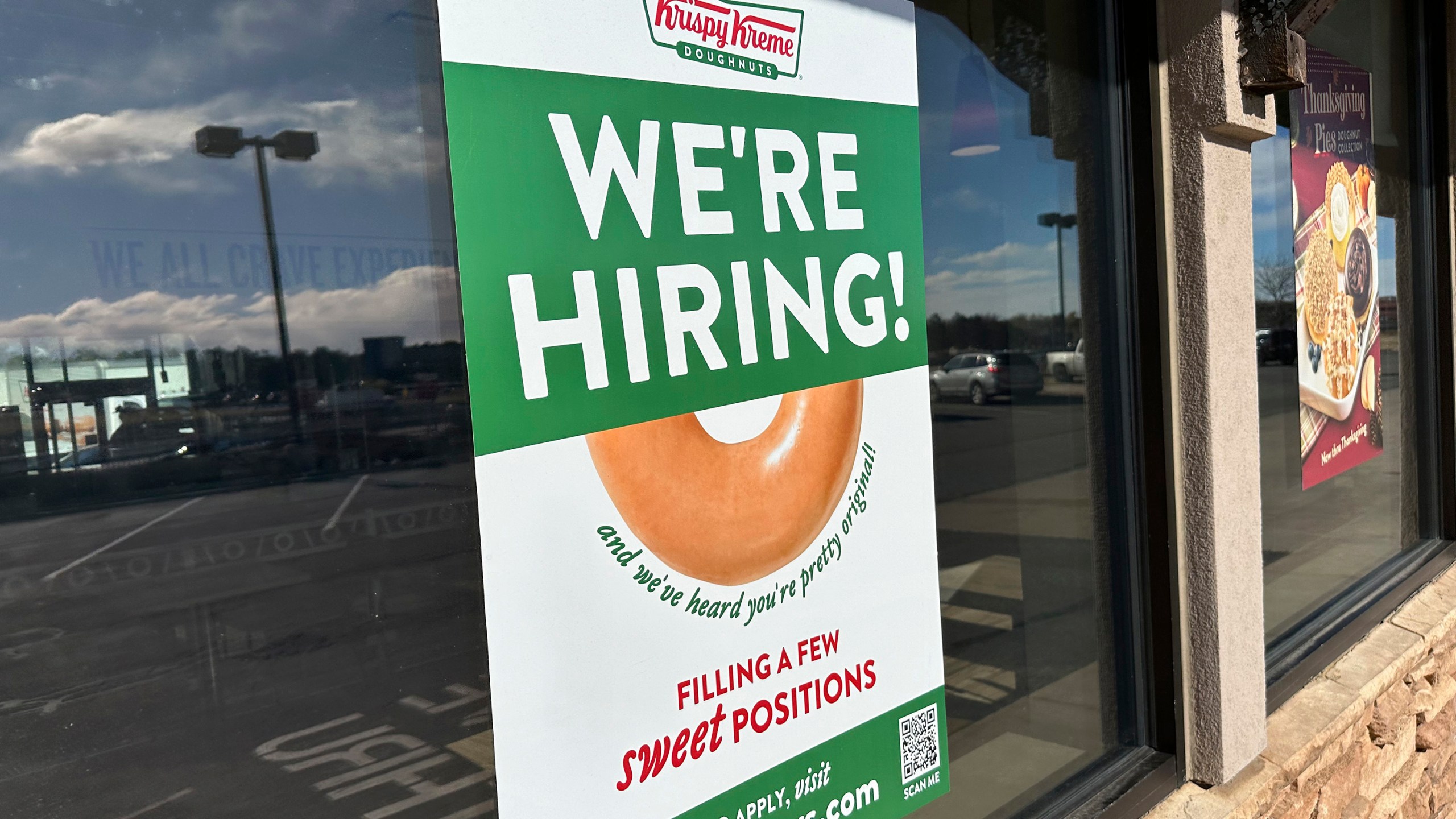 FILE - A hiring sign is displayed in the window of a Krispy Kreme donut shop on Nov. 19, 2024, in Lone Tree, Colo. (AP Photo/David Zalubowski, File)