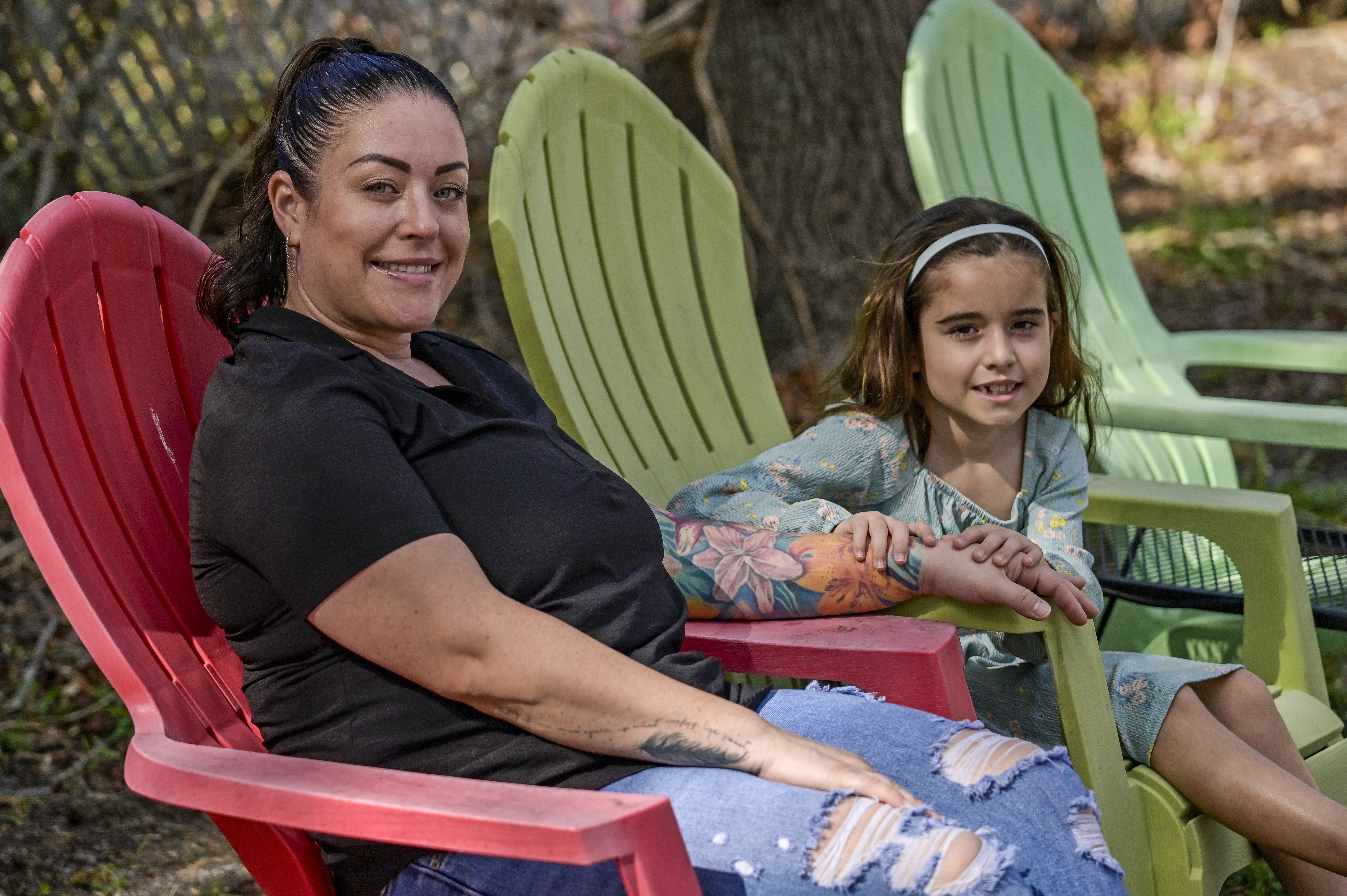 CORRECTS SPELLING OF SUBJECTS FIRST NAME TO CECILIA - Cecilia Grove and her daughter Aria Grove sit outside their home Saturday, Nov. 16, 2024, in Sarasota, Fla. (AP Photo/Steve Nesius)