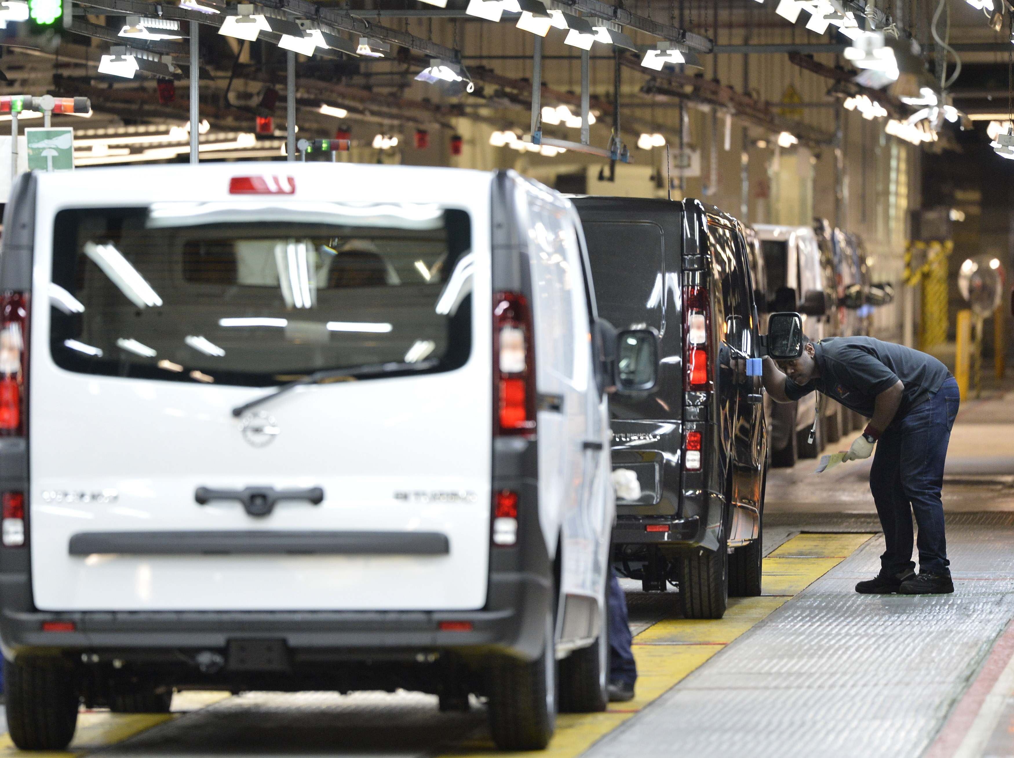 An employee inspects a car at the Vauxhall vehicle production plant in Luton, England, Feb. 2, 2015. Toby Melville/PA via AP)