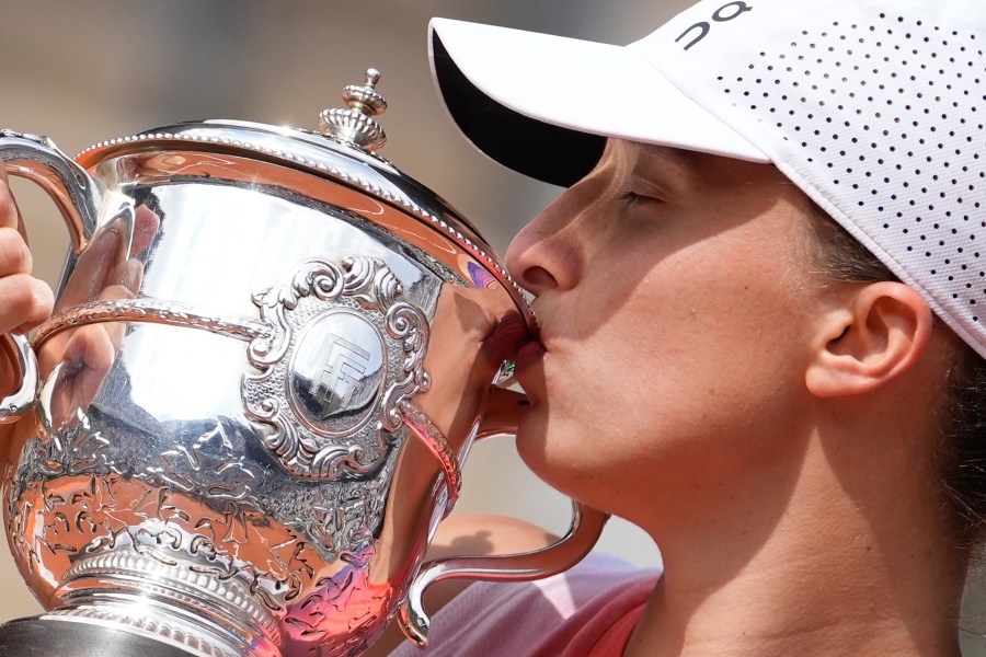 FILE - Poland's Iga Swiatek kisses the trophy after winning the women's final of the French Open tennis tournament against Italy's Jasmine Paolini at the Roland Garros stadium in Paris, France, Saturday, June 8, 2024. (AP Photo/Thibault Camus, File)