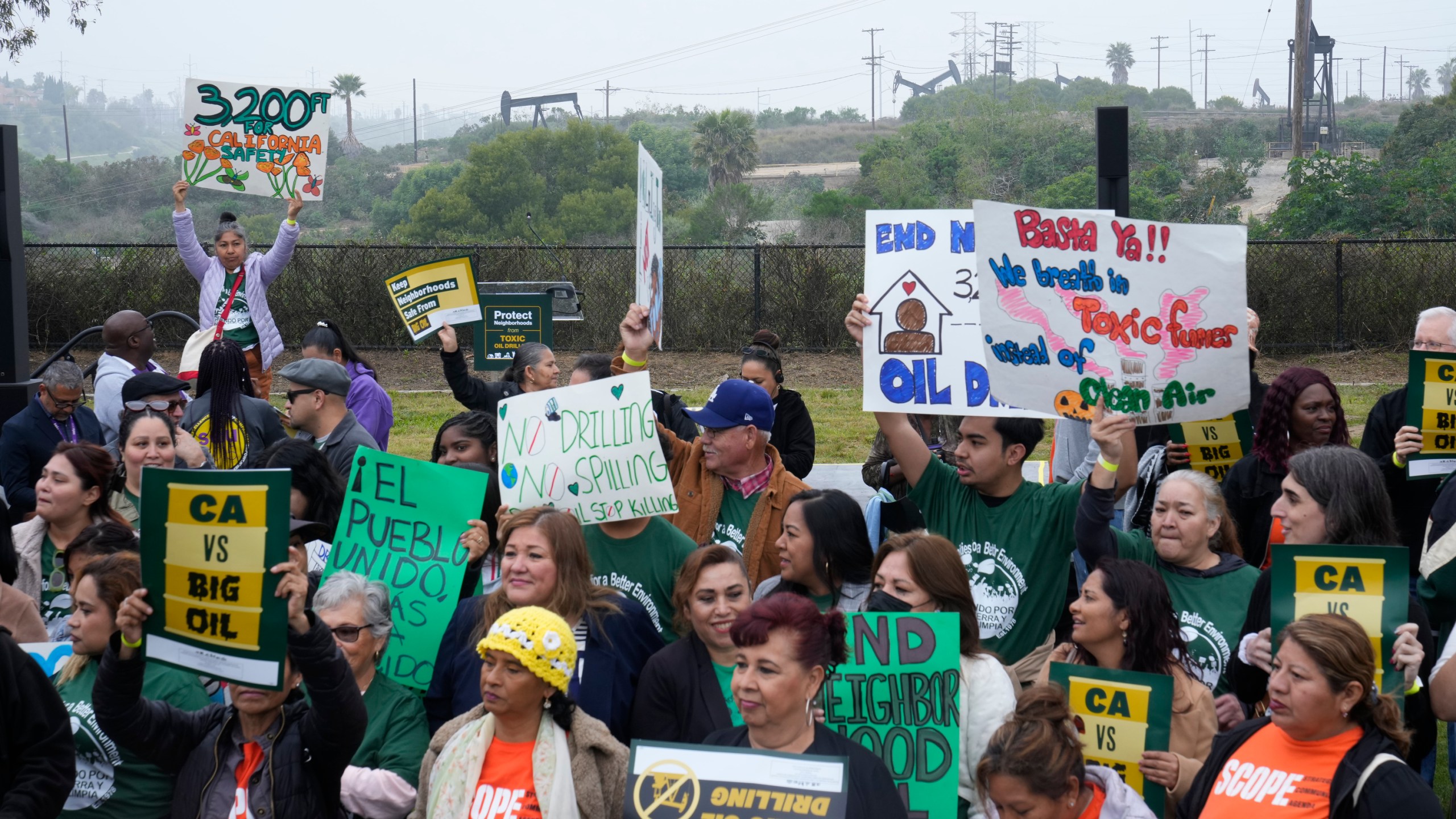 FILE - Members of Campaign for a Safe and Healthy California coalition campaign for Keep The Law (SB 1137) next to the Inglewood Oil Field in Inglewood, Calif., March. 22, 2024. (AP Photo/Damian Dovarganes, File)