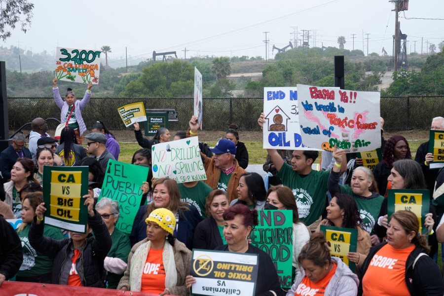 FILE - Members of Campaign for a Safe and Healthy California coalition campaign for Keep The Law (SB 1137) next to the Inglewood Oil Field in Inglewood, Calif., March. 22, 2024. (AP Photo/Damian Dovarganes, File)