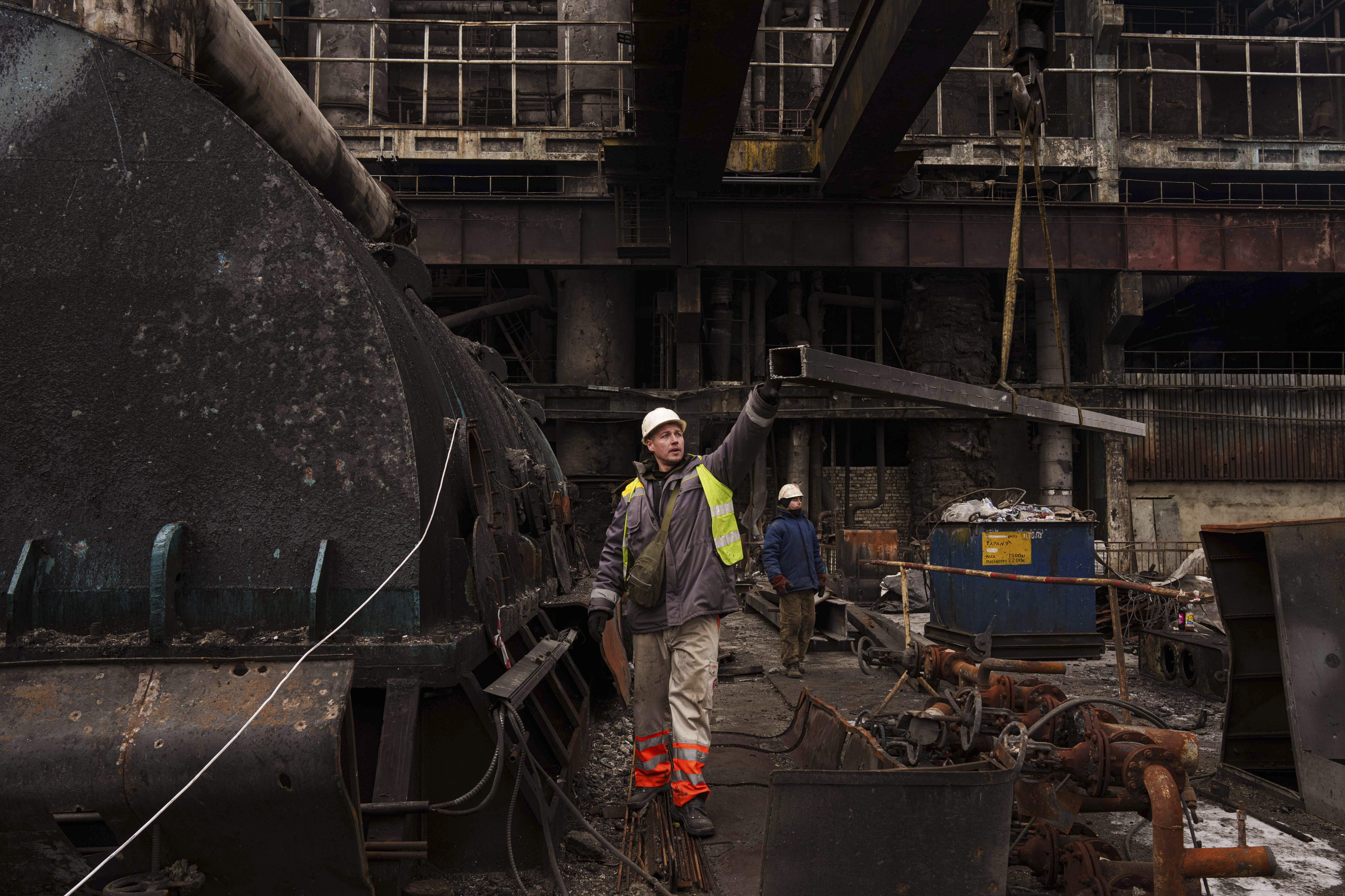 A worker lowers a metal bar to the ground using a crane during repairs to DTEK's power plant after a recent Russian missile attack in Ukraine, Nov. 28, 2024. (AP Photo/Evgeniy Maloletka)