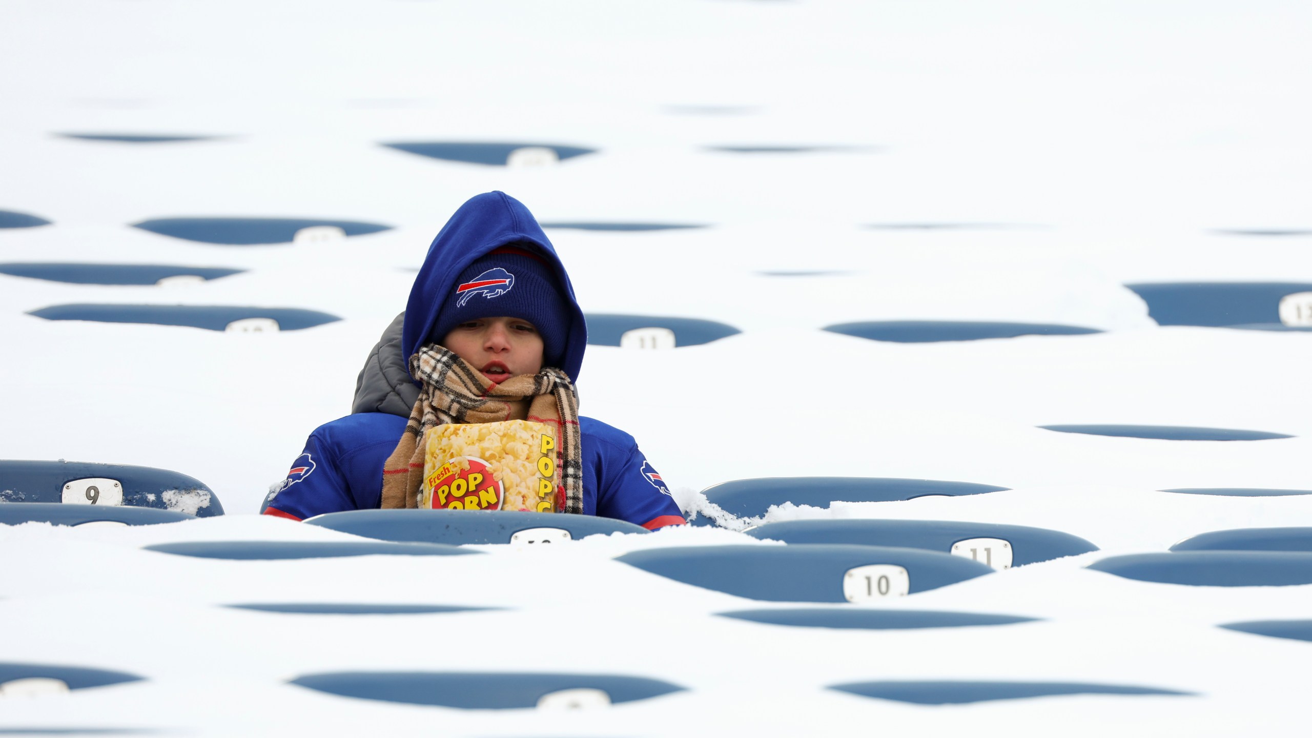 FILE - In this photo from last January, a Buffalo Bills fan sits amongst snow covered seats while waiting for the start an NFL wild-card playoff football game between the Buffalo Bills and the Pittsburgh Steelers, Jan. 15, 2024, in Buffalo, N.Y. (AP Photo/Jeffrey T. Barnes, File)