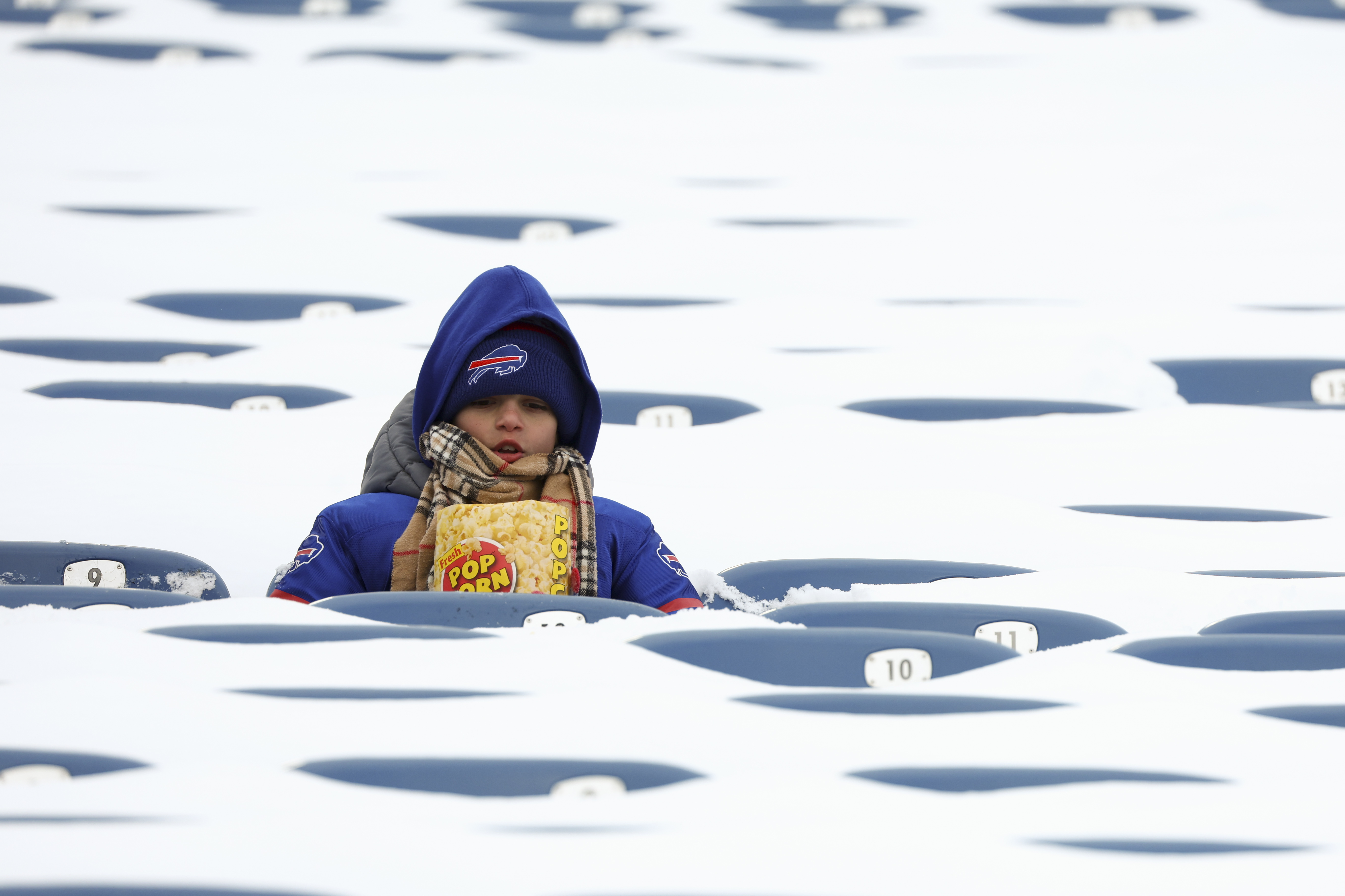 FILE - In this photo from last January, a Buffalo Bills fan sits amongst snow covered seats while waiting for the start an NFL wild-card playoff football game between the Buffalo Bills and the Pittsburgh Steelers, Jan. 15, 2024, in Buffalo, N.Y. (AP Photo/Jeffrey T. Barnes, File)