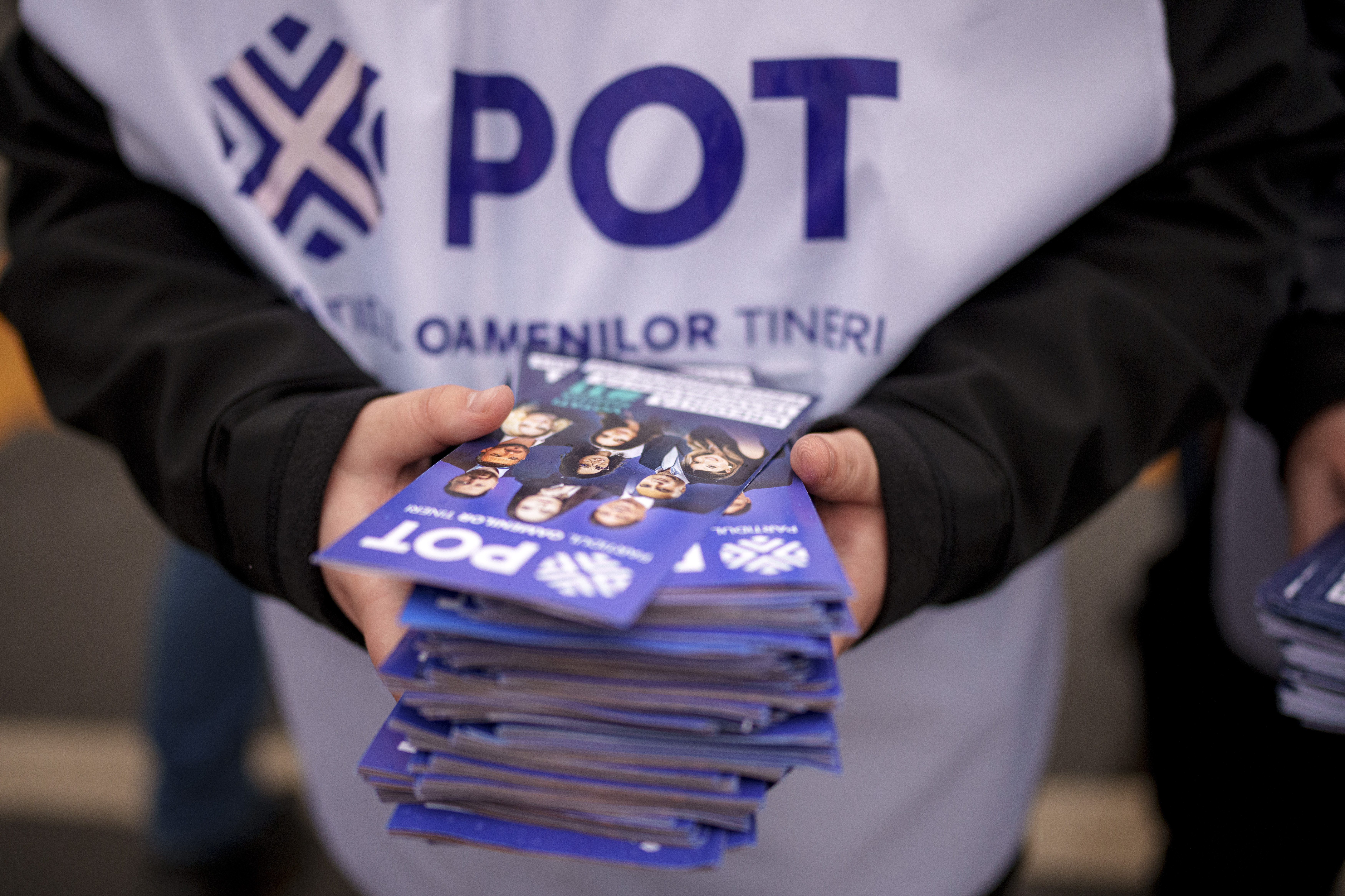 A man distributes leaflets of the Young People's Party or POT, which has backed Calin Georgescu, an independent candidate who won the first round of presidential elections, in Bucharest, Romania, Friday, Nov. 29, 2024. (AP Photo/Andreea Alexandru)