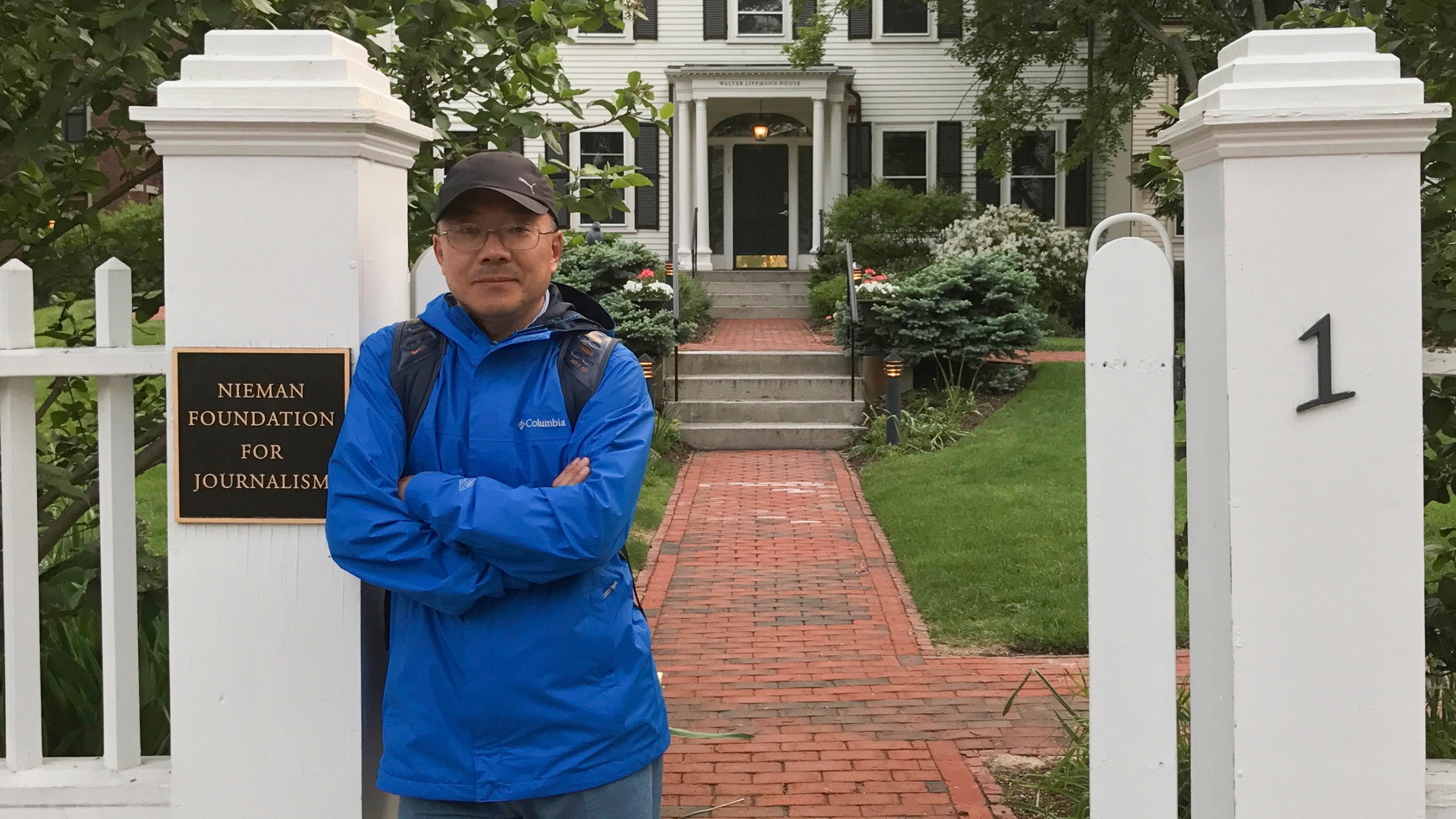 In this photo provided by the Dong family, Chinese journalist Dong Yuyu stands at the gates of the Nieman Foundation for Journalism at Harvard University in Cambridge, Mass., in May 2017. (Courtesy Dong Family via AP)