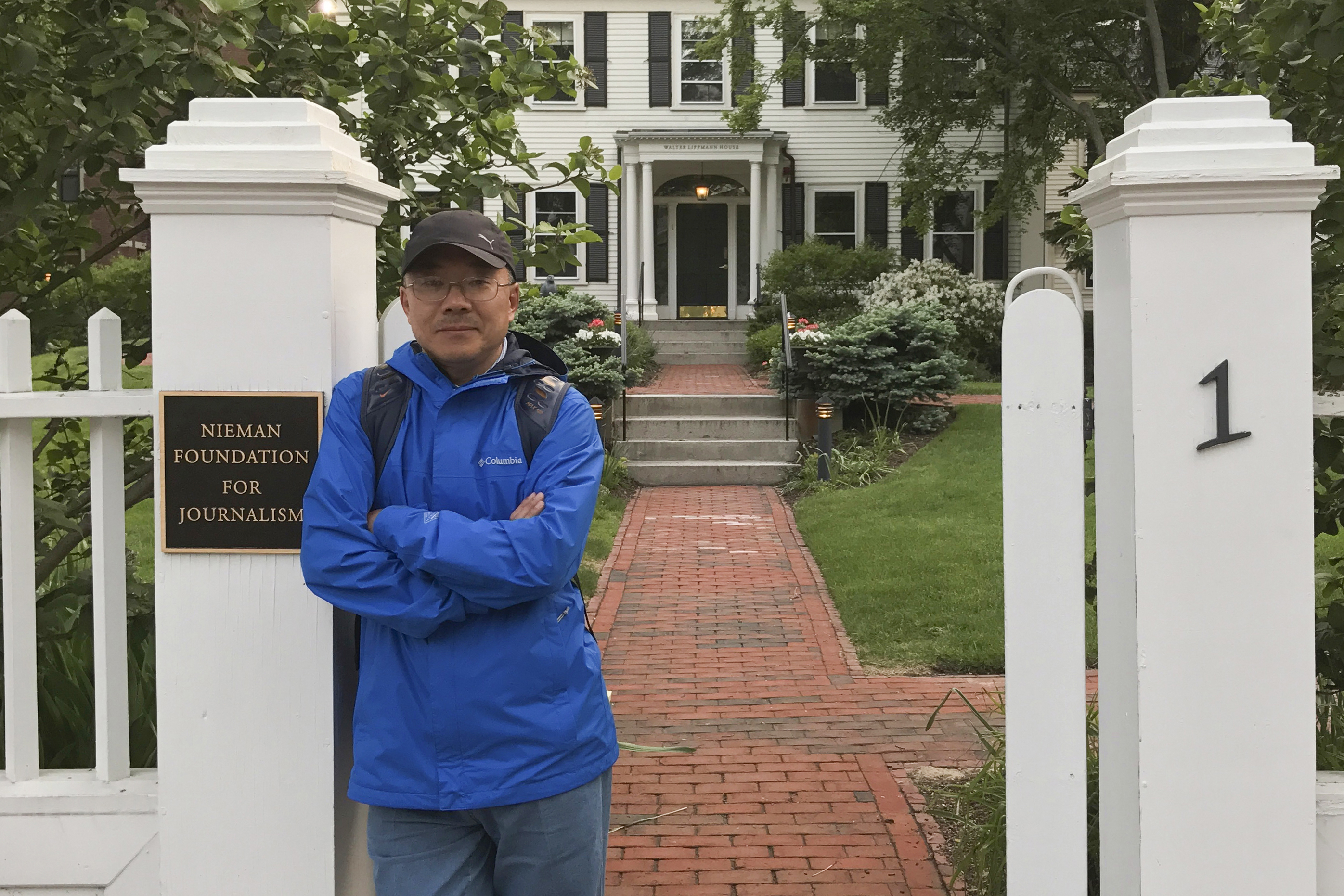 In this photo provided by the Dong family, Chinese journalist Dong Yuyu stands at the gates of the Nieman Foundation for Journalism at Harvard University in Cambridge, Mass., in May 2017. (Courtesy Dong Family via AP)