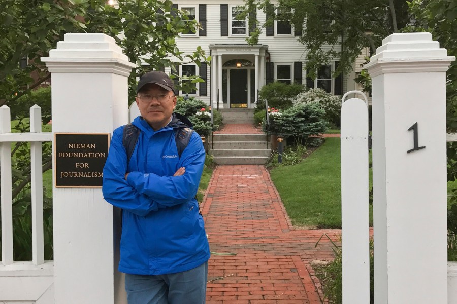 In this photo provided by the Dong family, Chinese journalist Dong Yuyu stands at the gates of the Nieman Foundation for Journalism at Harvard University in Cambridge, Mass., in May 2017. (Courtesy Dong Family via AP)