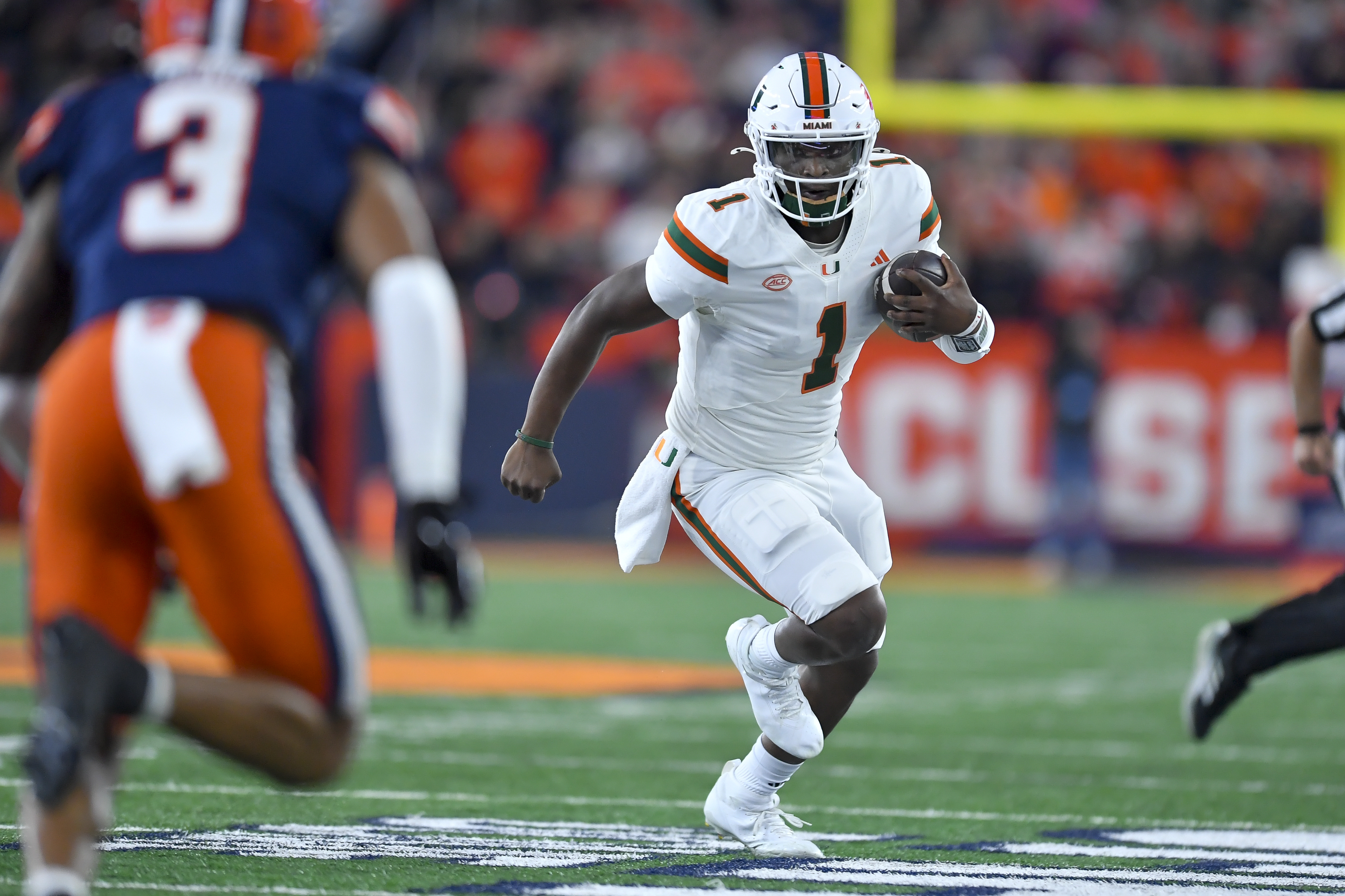 Miami quarterback Cam Ward (1) runs with the ball during the first half of an NCAA college football game against Syracuse on Saturday, Nov. 30, 2024 in Syracuse, N.Y. (AP Photo/Adrian Kraus)