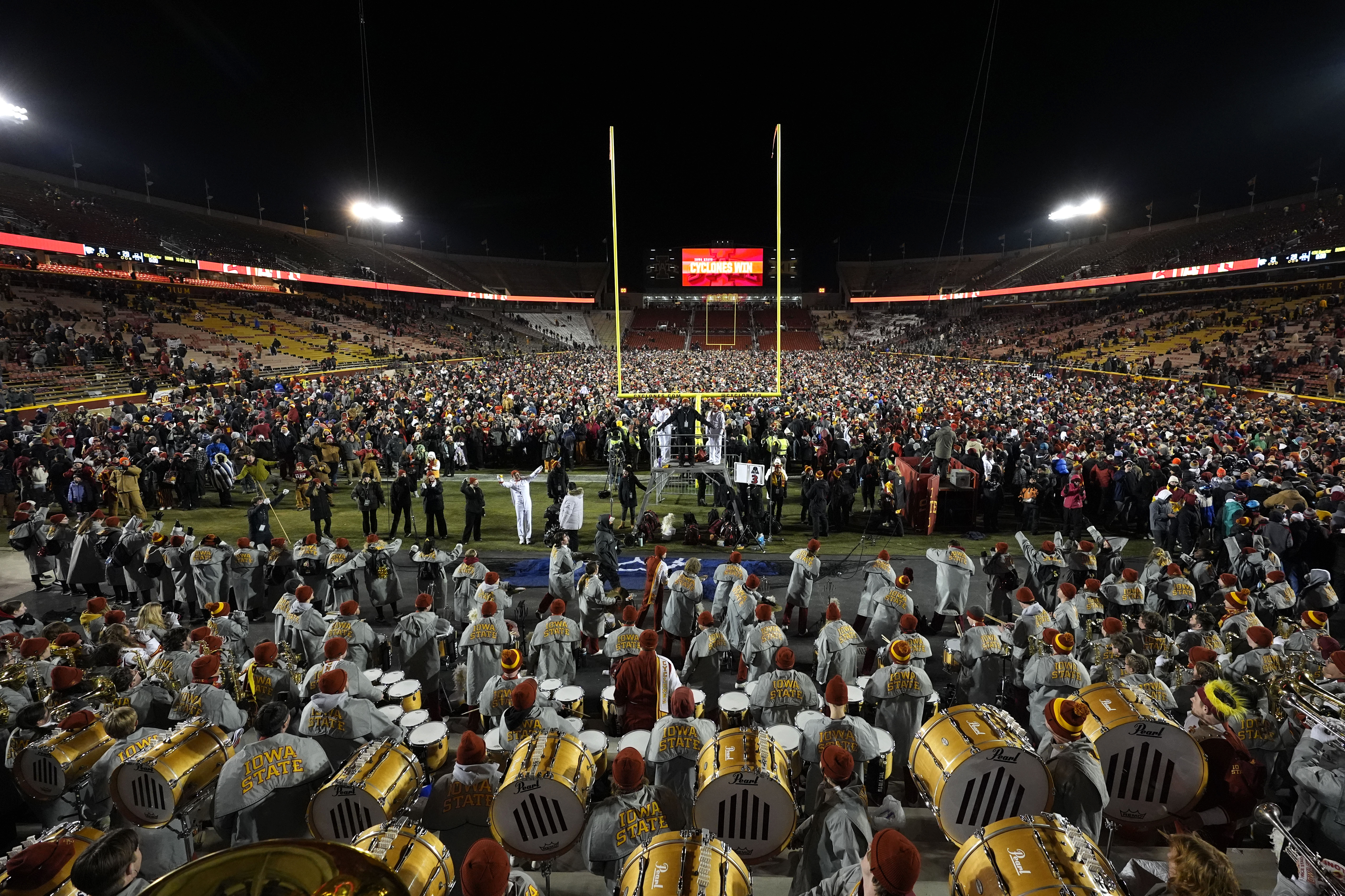 Fans celebrate on the field after an NCAA college football game between Iowa State and Kansas State, Saturday, Nov. 30, 2024, in Ames, Iowa. (AP Photo/Charlie Neibergall)