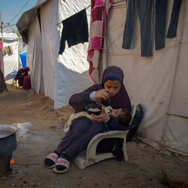 Asma Al-Kharobi, 16, feeds her 10-month-old baby sister bread mixed with water at a camp for displaced Palestinians in Deir al-Balah, Gaza Strip, on Sunday, Dec. 1, 2024. (AP Photo/Abdel Kareem Hana)