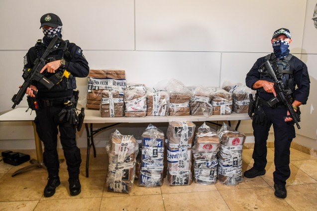 Australian Federal Police officers stand with approximately 350 kilograms (770 pounds) of seized cocaine at a press conference at the AFP headquarters in Brisbane, Australia, Monday, Dec. 2, 2024. (Jono Searle/AAP Image via AP)