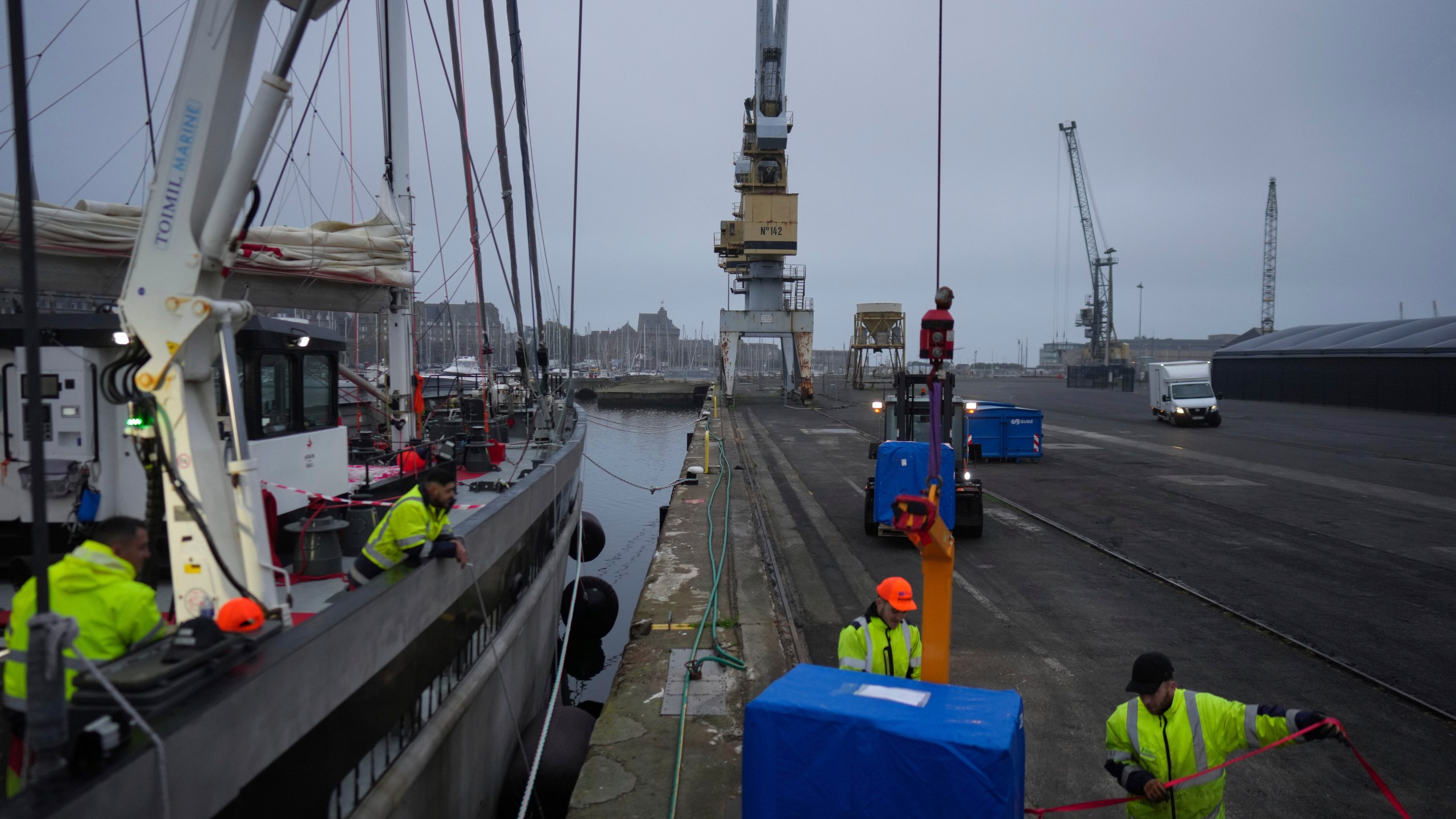 Dockers load pallets onto the sailboat 'Grain de Sail II' at the port of Saint Malo, western France, Nov. 8, 2024. (AP Photo/Thibault Camus)