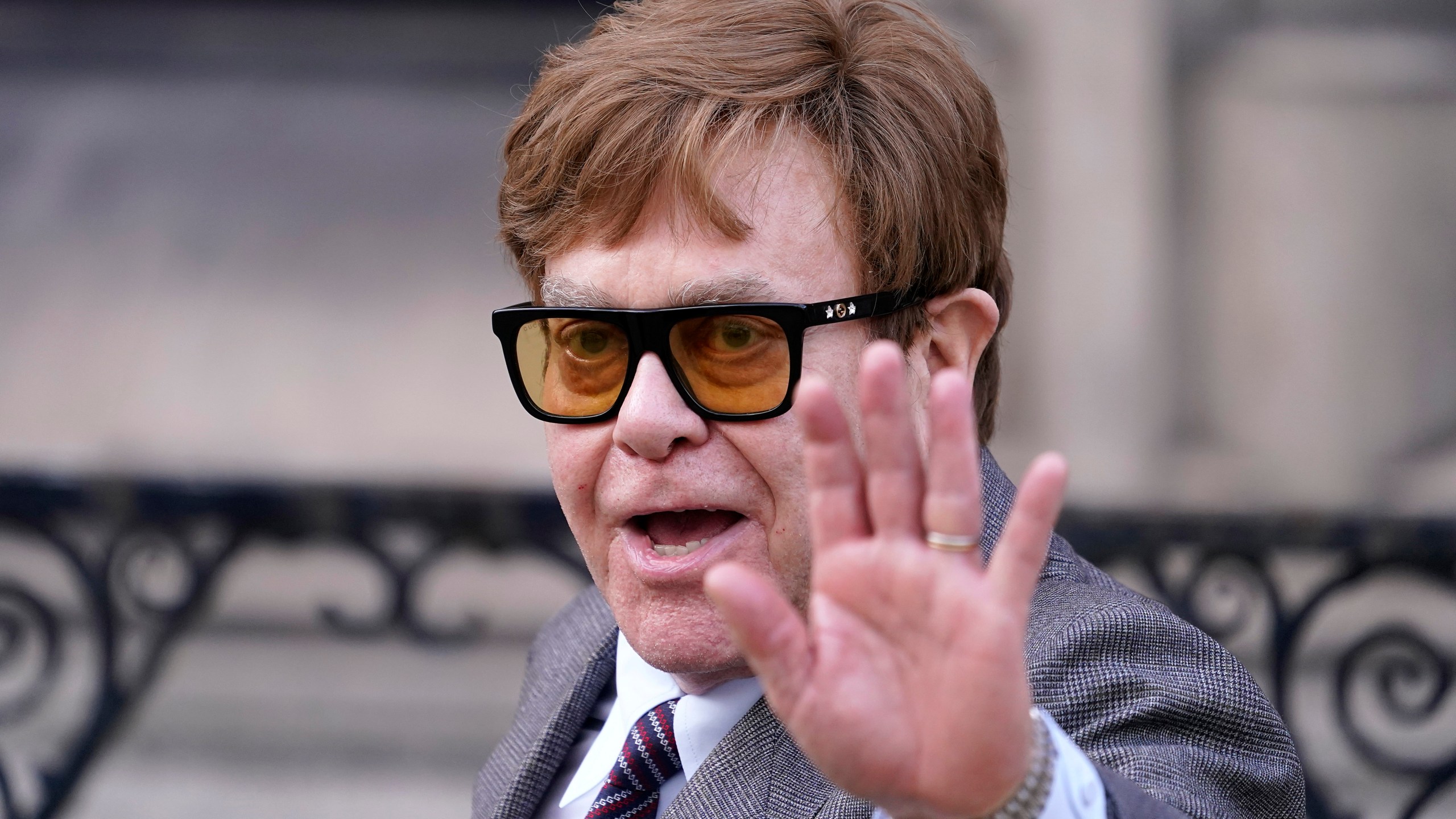 FILE - Elton John waves to the waiting media as he leaves the Royal Courts Of Justice in London, Monday, March 27, 2023. (AP Photo/Alberto Pezzali, File)