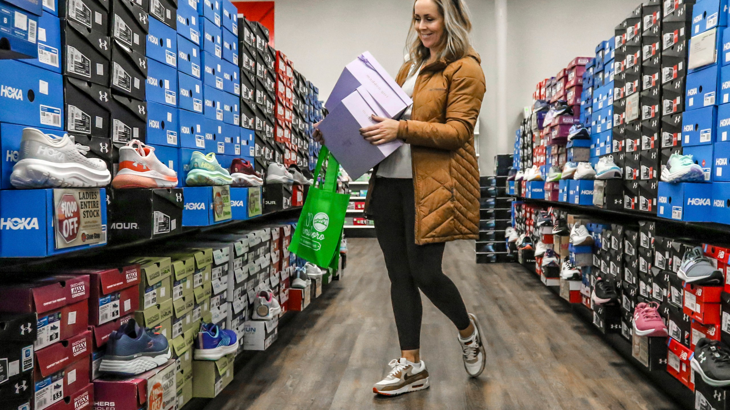 FILE - Ashley Crafton looks at tennis shoes at at Shoe Stop while shopping during Small Business Saturday in Wesleyan Park Plaza on Nov. 25, 2023, in Owensboro, Ky. (Greg Eans/The Messenger-Inquirer via AP, File)