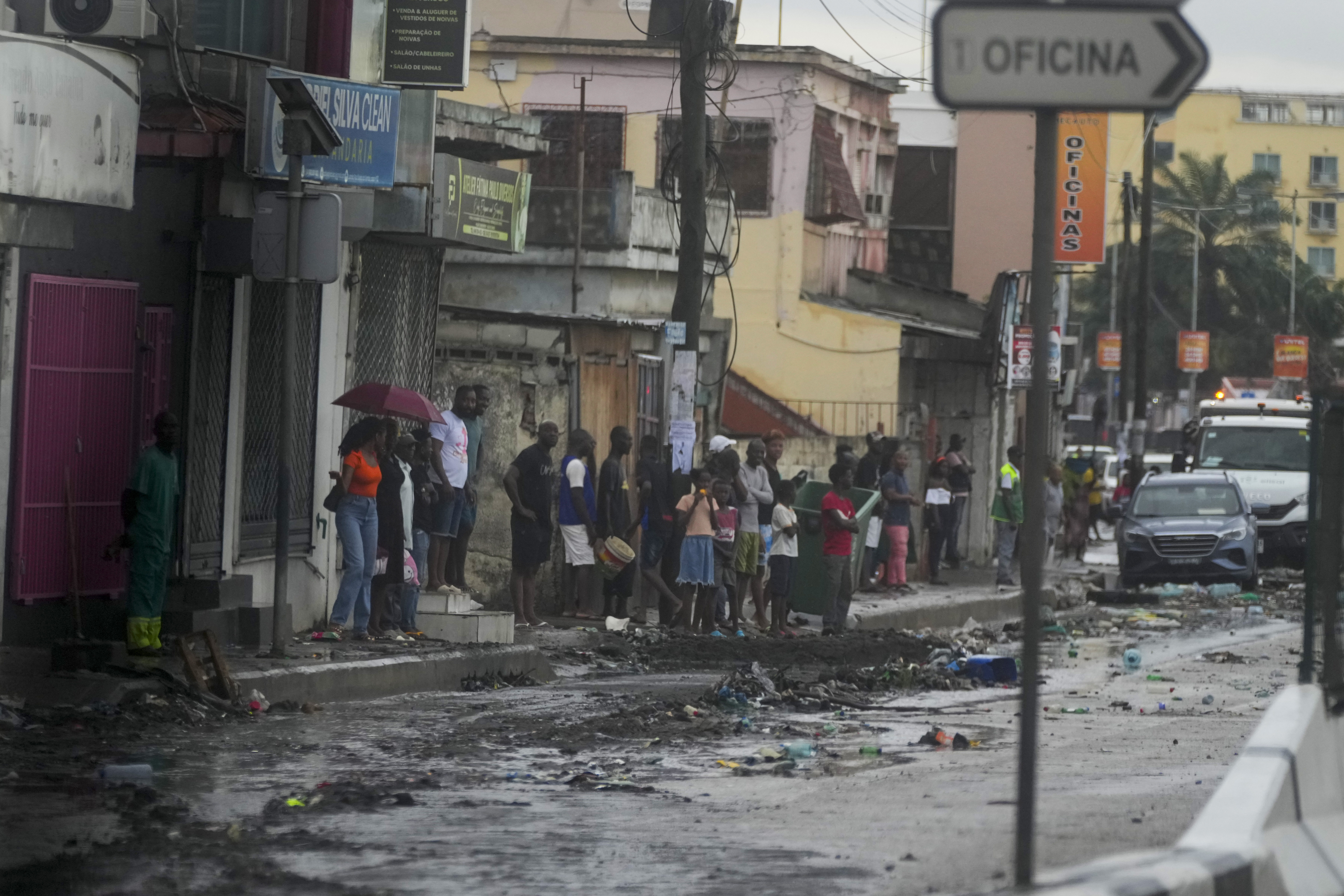 People watch President Joe Biden's motorcade drive through Luanda, Angola, Tuesday, Dec. 3, 2024. (AP Photo/Ben Curtis)