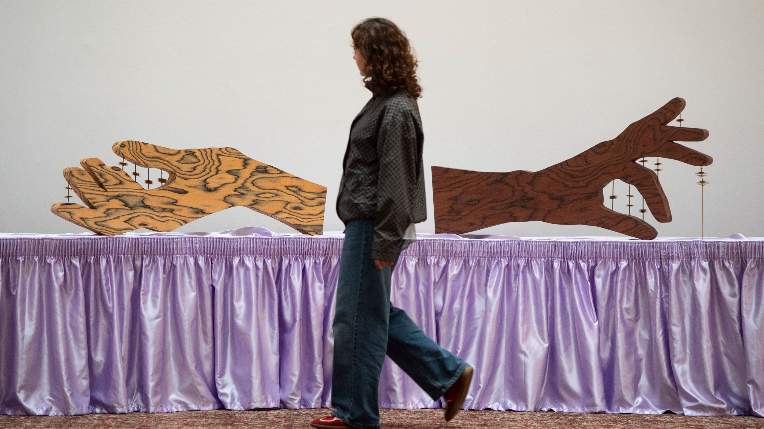 FILE - A woman walks past an artwork by Jasleen Kaur during the Turner Prize 2024 press preview at Tate Britain in London, Sept. 24, 2024. (AP Photo/Thomas Krych)