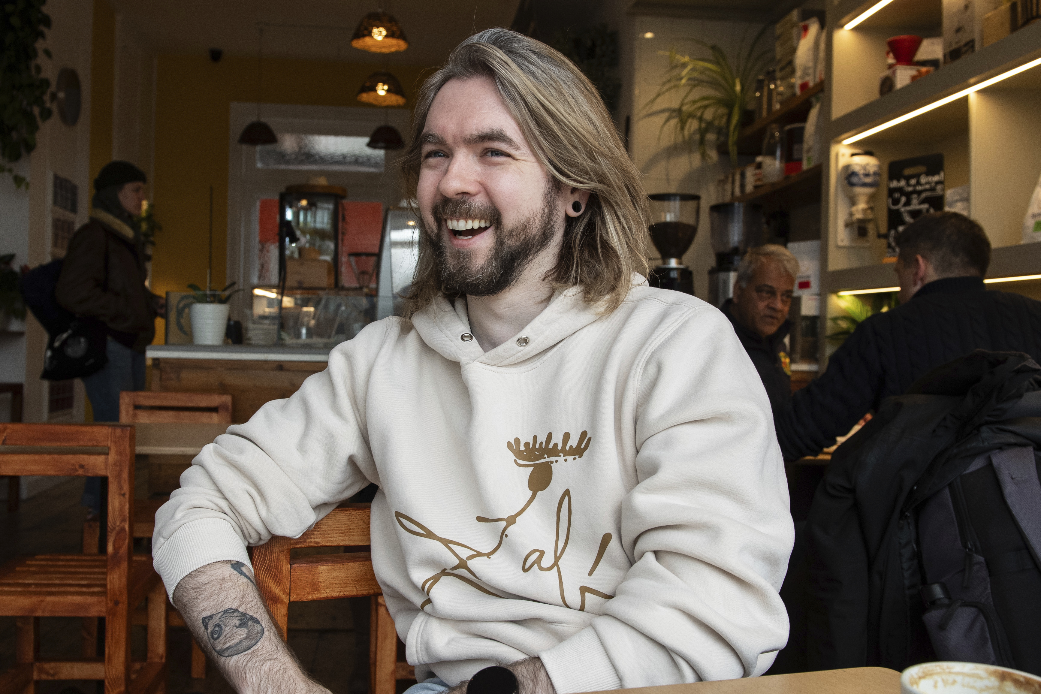 YouTuber Sean McLoughlin, better known as 'Jacksepticeye,' drinks a coffee at his favorite coffee shop in Brighton, Thursday, November 21, 2024. (AP Photo/Thomas Krych)