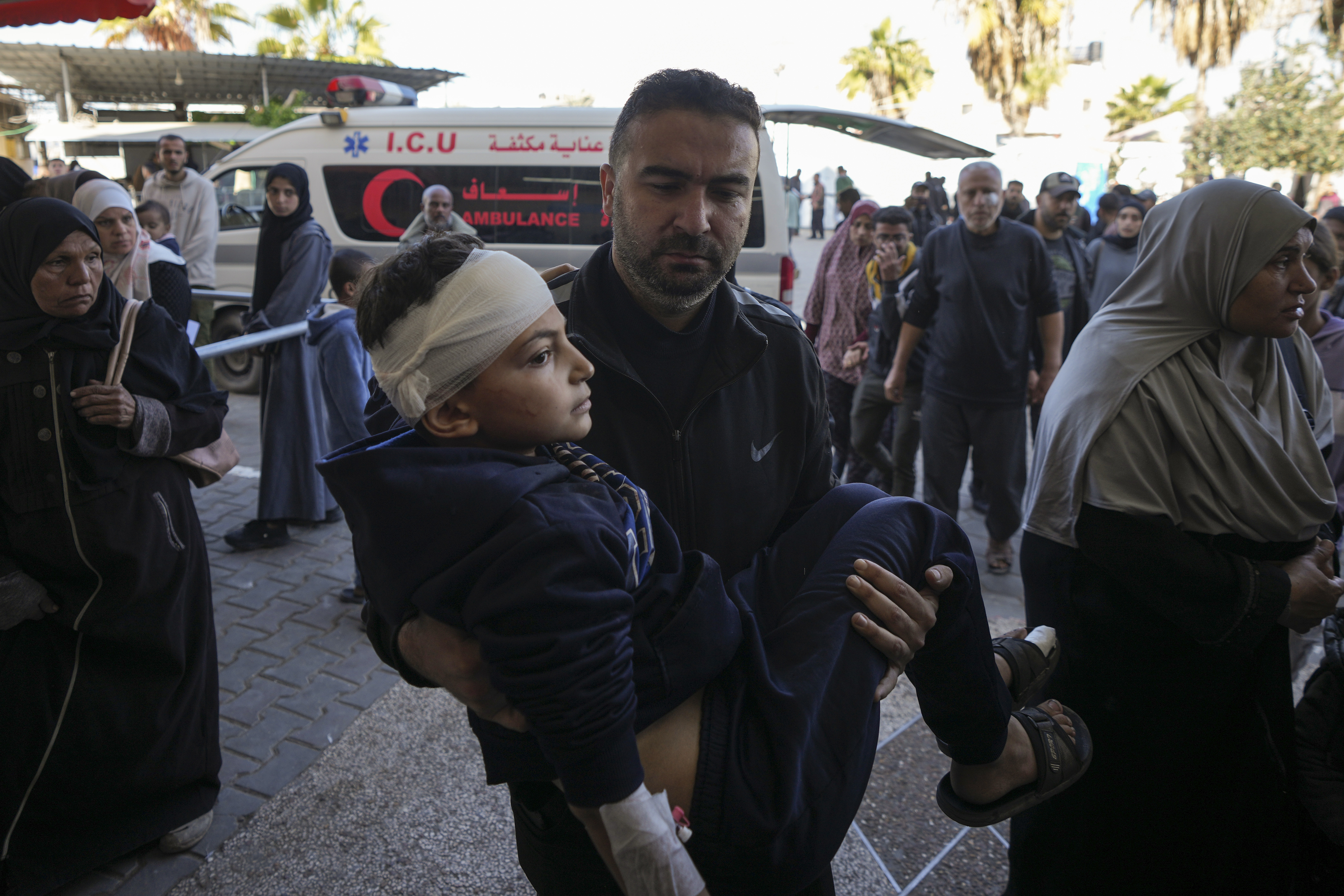 A Palestinian man carries a wounded child, following an Israeli bombardment in Nuseirat, central Gaza, as they arrive at the Al-Aqsa Martyrs hospital in Deir al-Balah, Gaza Strip Wednesday, Dec. 4, 2024. (AP Photo/Abdel Kareem Hana)