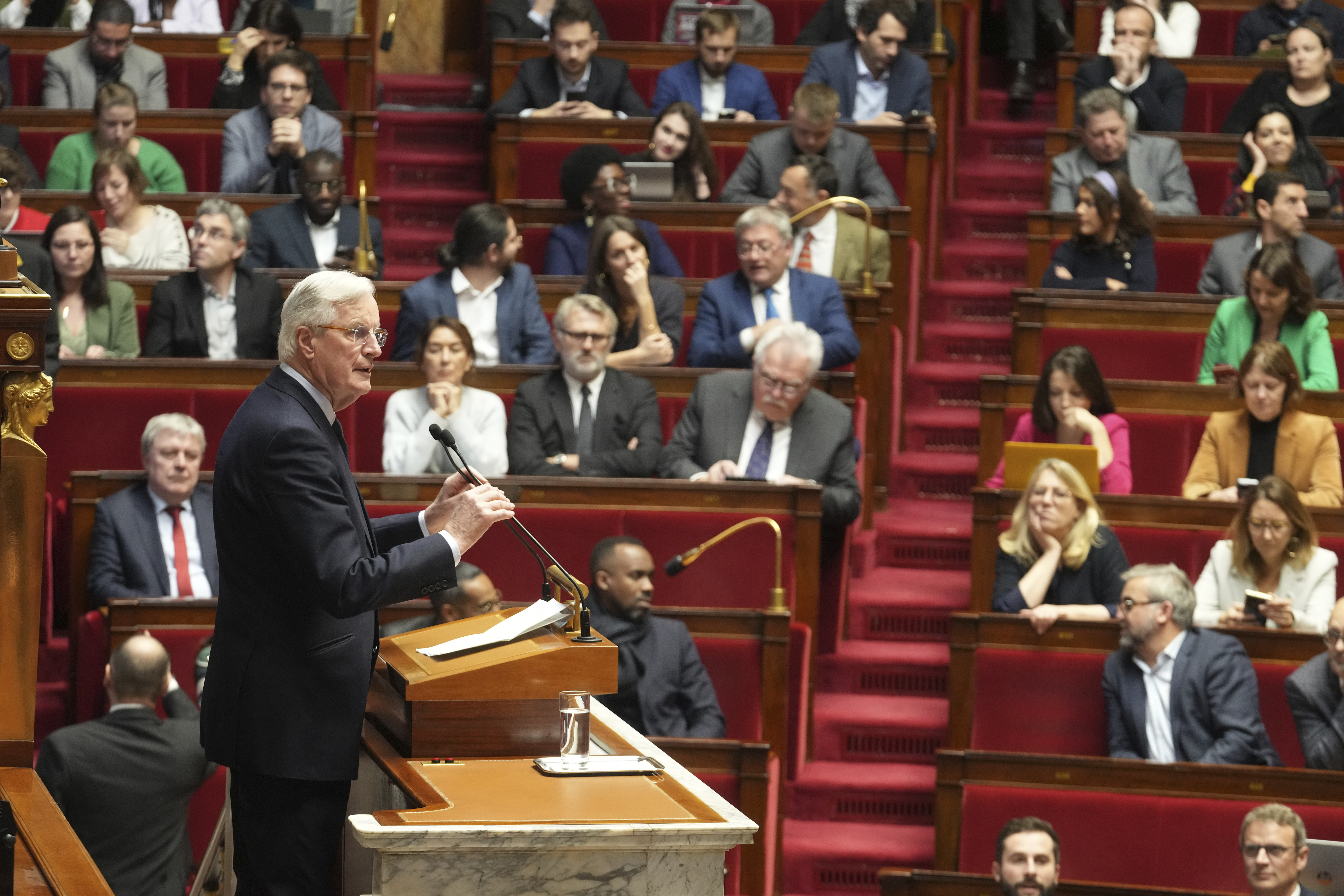 French Prime Minister Michel Barnier delivers his speech at the National Assembly while France's minority government may be on its last legs as opposition lawmakers moved this week toward a no-confidence vote, Monday, Dec. 2, 2024 in Paris. (AP Photo/Michel Euler)