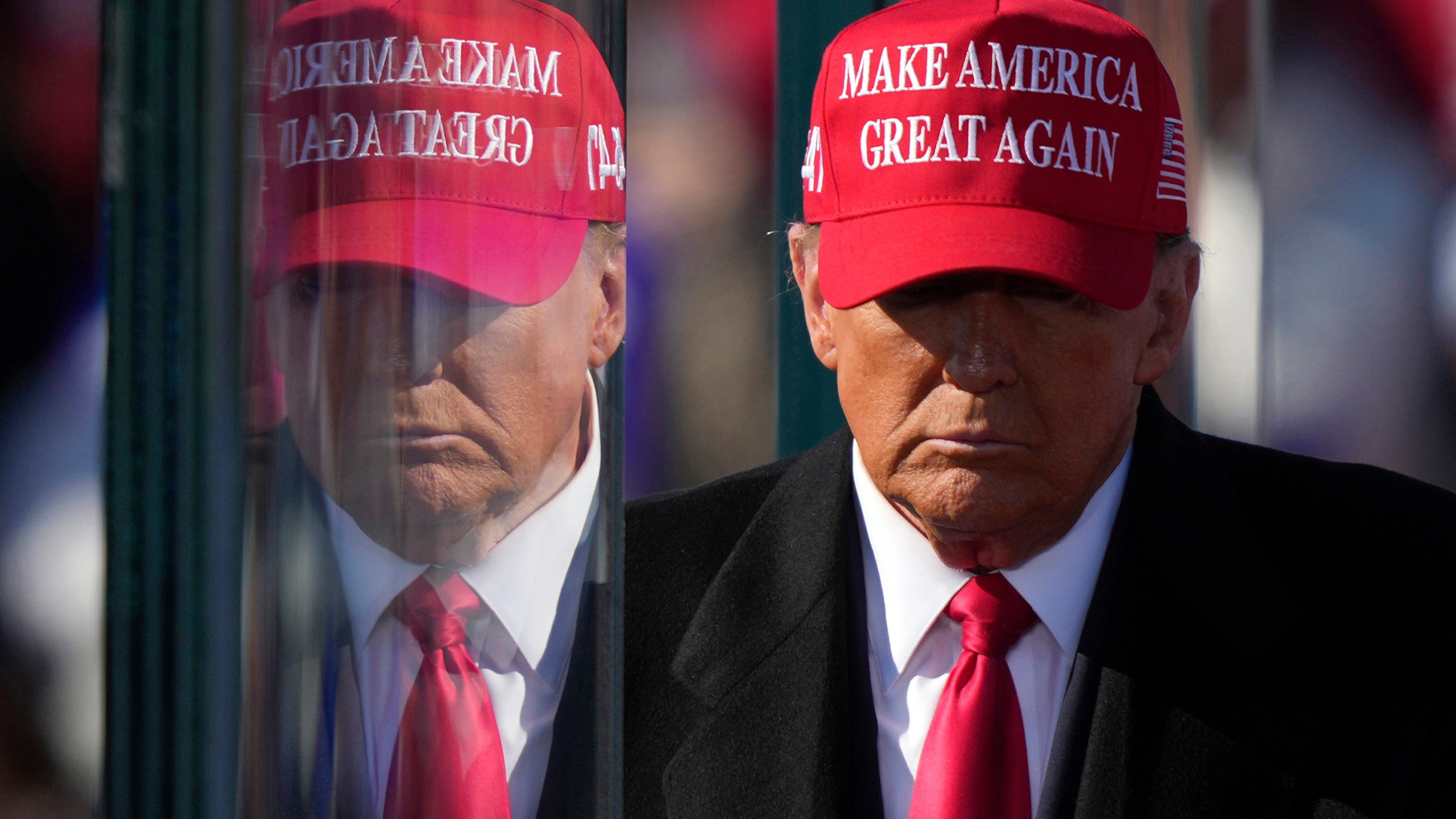 Republican presidential nominee former President Donald Trump is reflected in the bullet proof glass as he finishes speaking at a campaign rally in Lititz, Pa., Sunday, Nov. 3, 2024. (AP Photo/Matt Rourke)