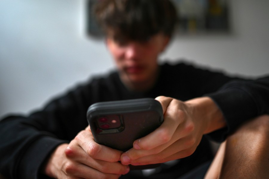 A teenager uses his mobile phone to access social media, Sydney, Wednesday, Nov. 13, 2024. (Dean Lewins/AAP Image VIA AP)