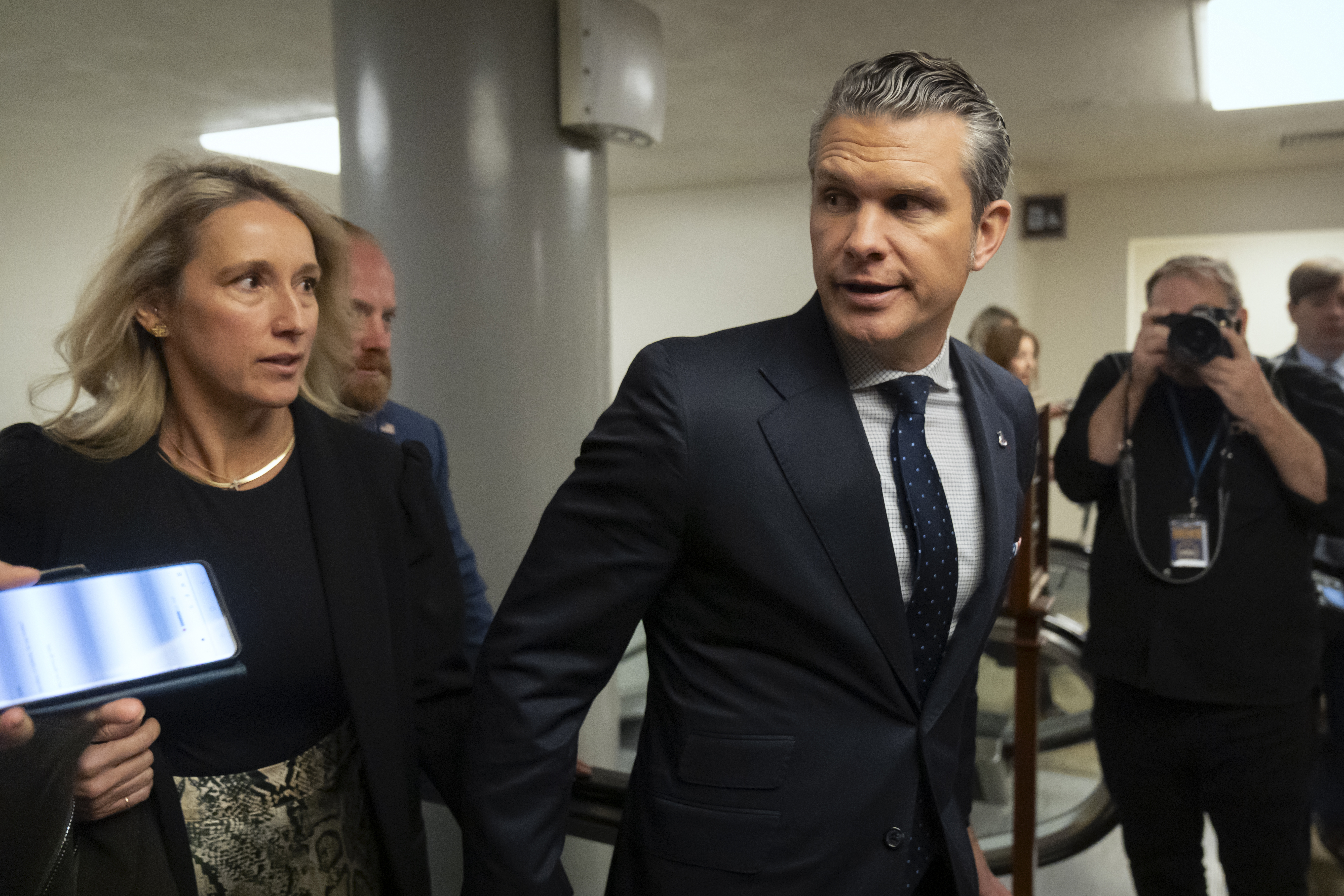 Pete Hegseth, President-elect Donald Trump's nominee to be defense secretary, is joined by his wife Jennifer Rauchet, as they walk through the basement of the Capitol, Wednesday, Dec. 4, 2024, in Washington. (AP Photo/Mark Schiefelbein)