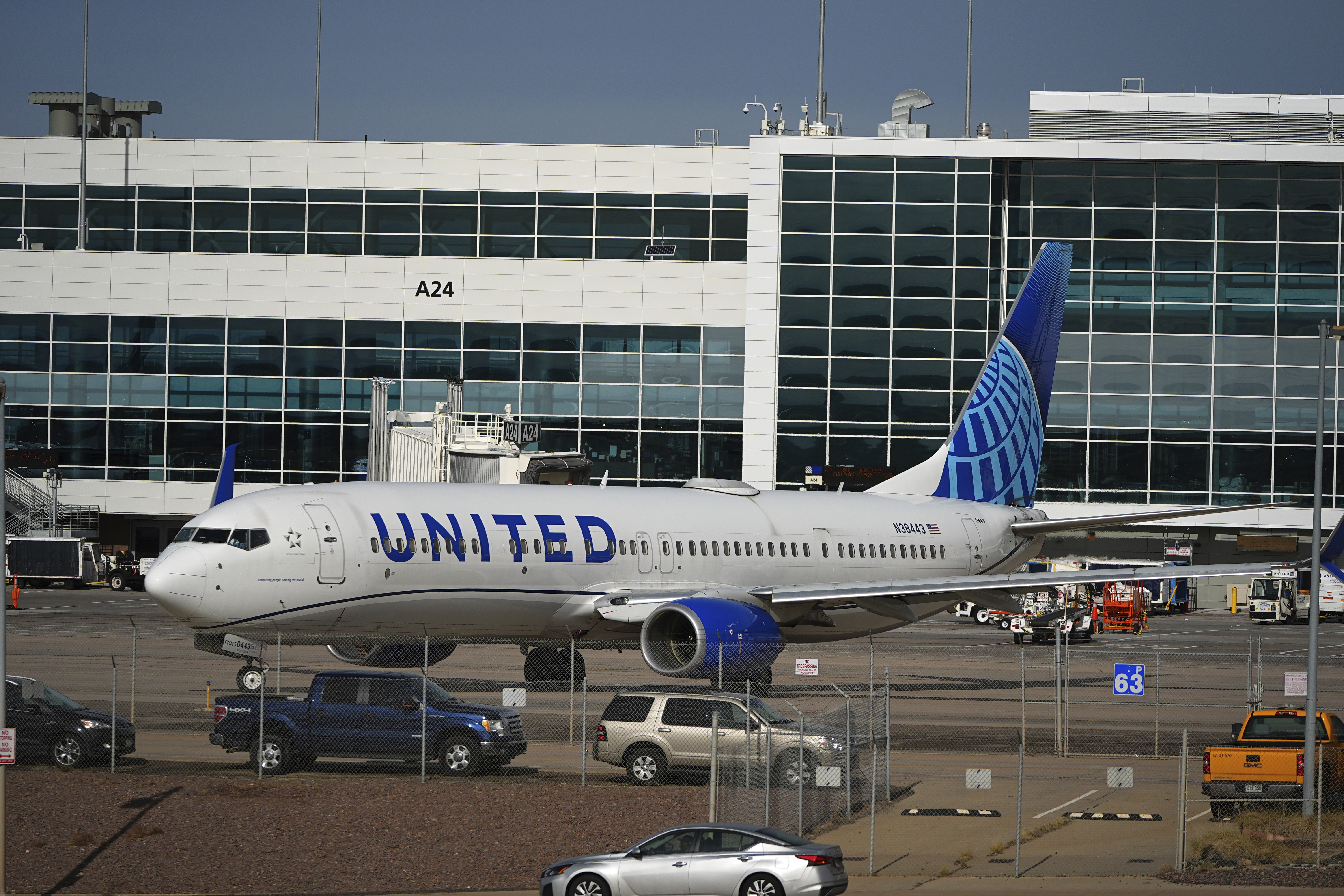 As traffic passes by in the foreground, a United Airlines jetliner turns on the tarmac to leave the A Concourse and head to a runway at Denver International Airport Tuesday, Nov. 26, 2024, in Denver. (AP Photo/David Zalubowski)