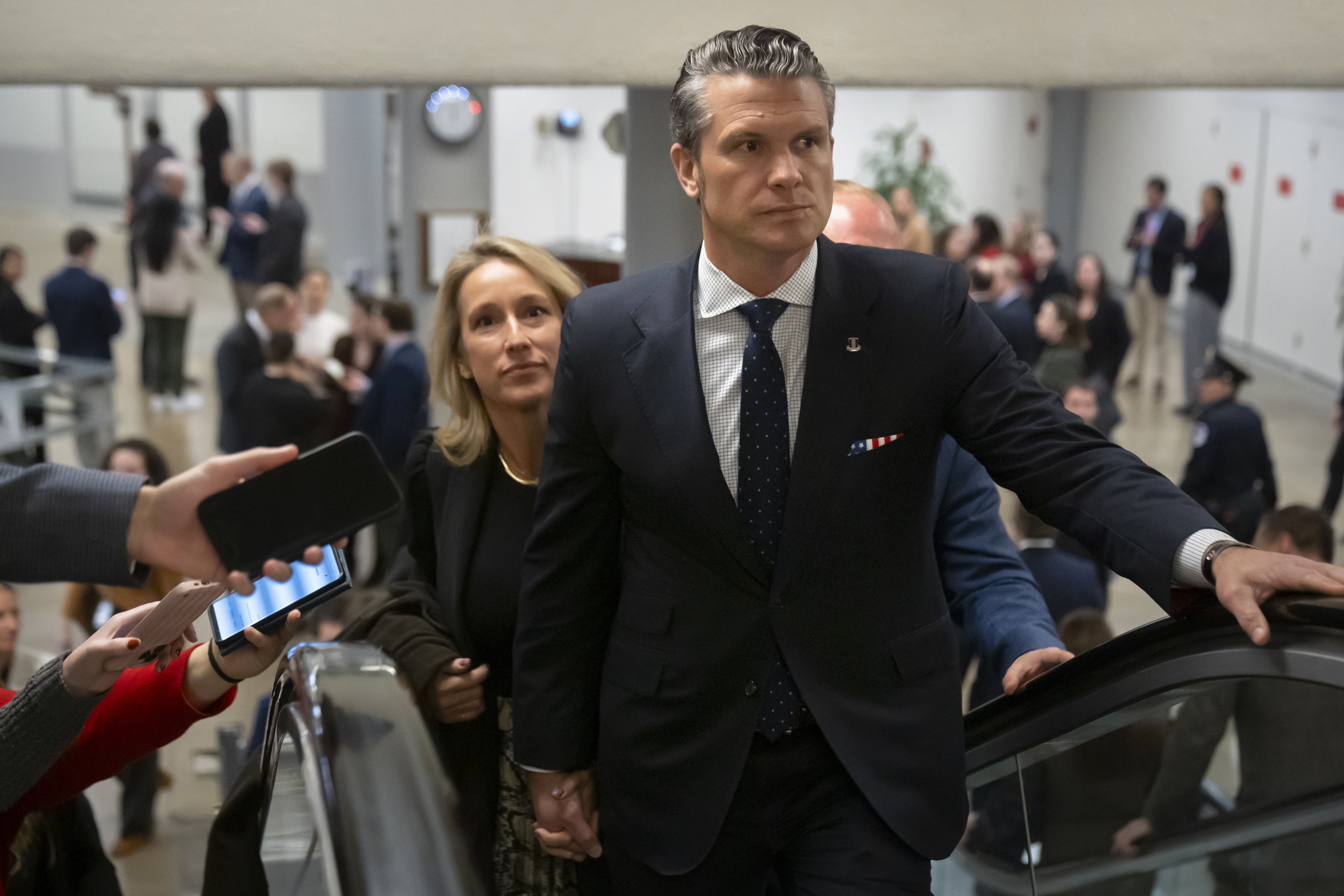 Pete Hegseth, President-elect Donald Trump's nominee to be defense secretary, is joined by his wife Jennifer Rauchet, as they walk through the basement of the Capitol, Wednesday, Dec. 4, 2024, in Washington. (AP Photo/Mark Schiefelbein)