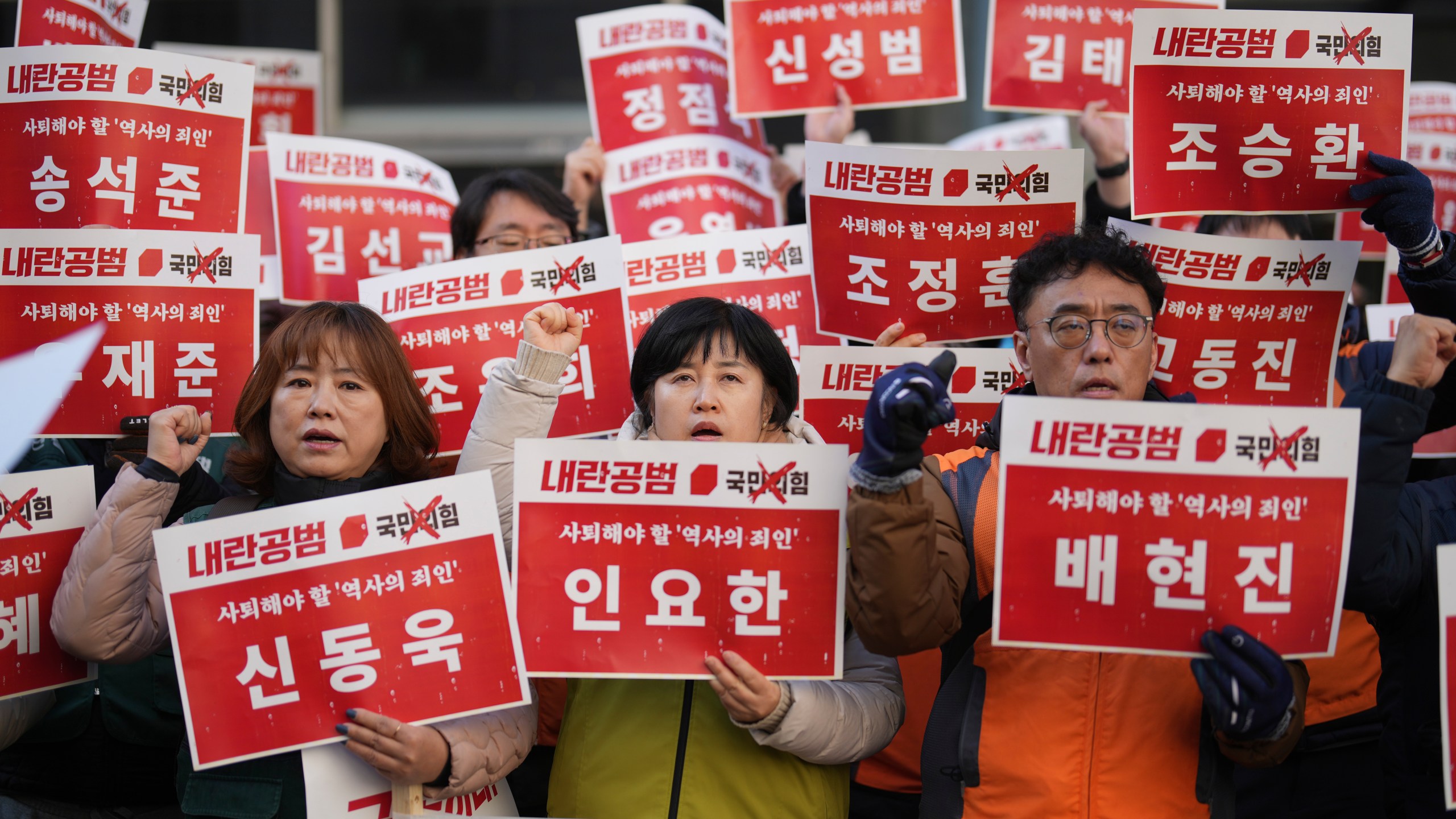 Members of the Korean Confederation of Trade Unions shout slogans as they hold signs carrying the names of the ruling party's lawmakers who didn't vote at the impeachment motion last week, during a rally in front of the ruling People Power Party's head office in Seoul, South Korea, Monday, Dec. 9, 2024. (AP Photo/Lee Jin-man)