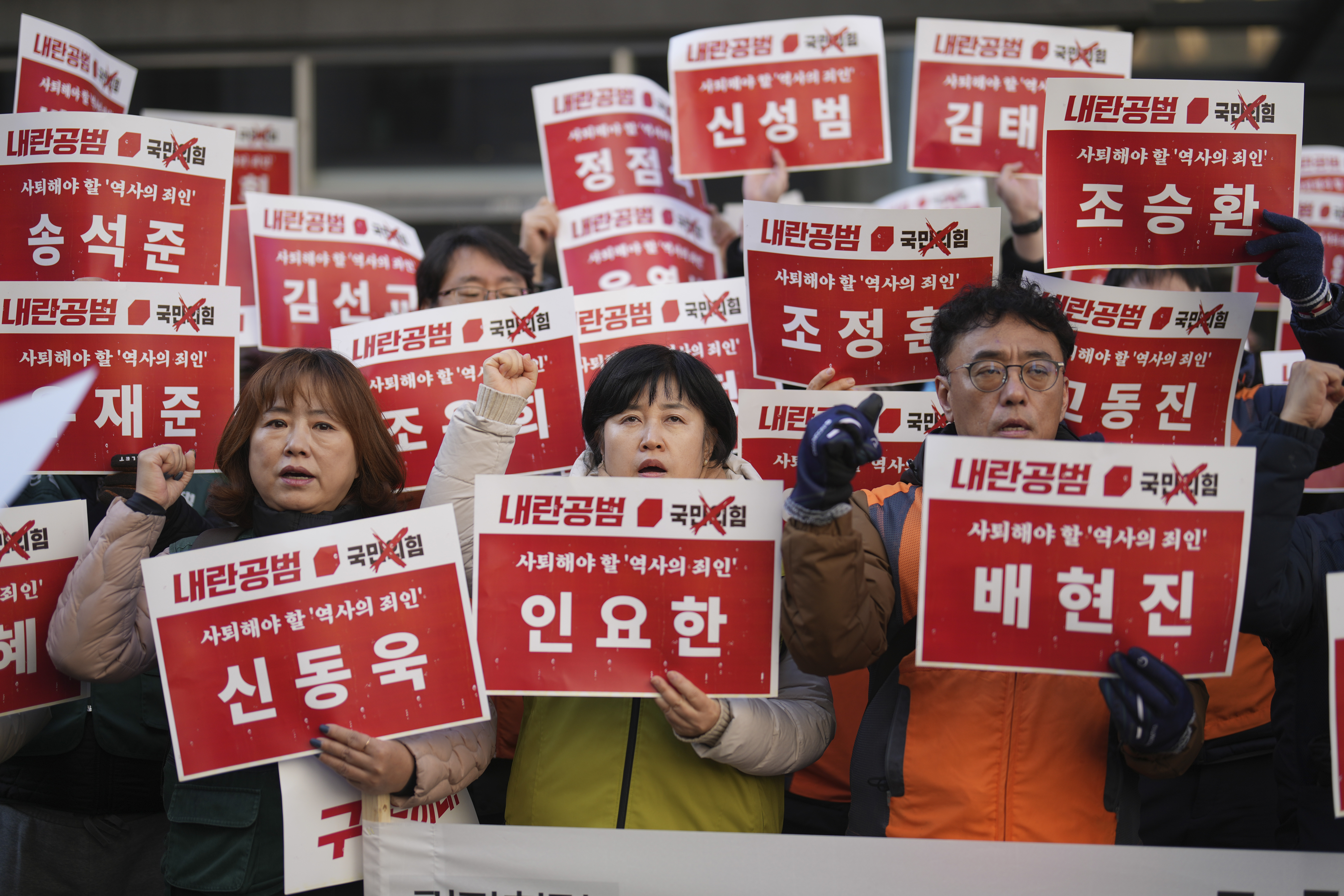 Members of the Korean Confederation of Trade Unions shout slogans as they hold signs carrying the names of the ruling party's lawmakers who didn't vote at the impeachment motion last week, during a rally in front of the ruling People Power Party's head office in Seoul, South Korea, Monday, Dec. 9, 2024. (AP Photo/Lee Jin-man)